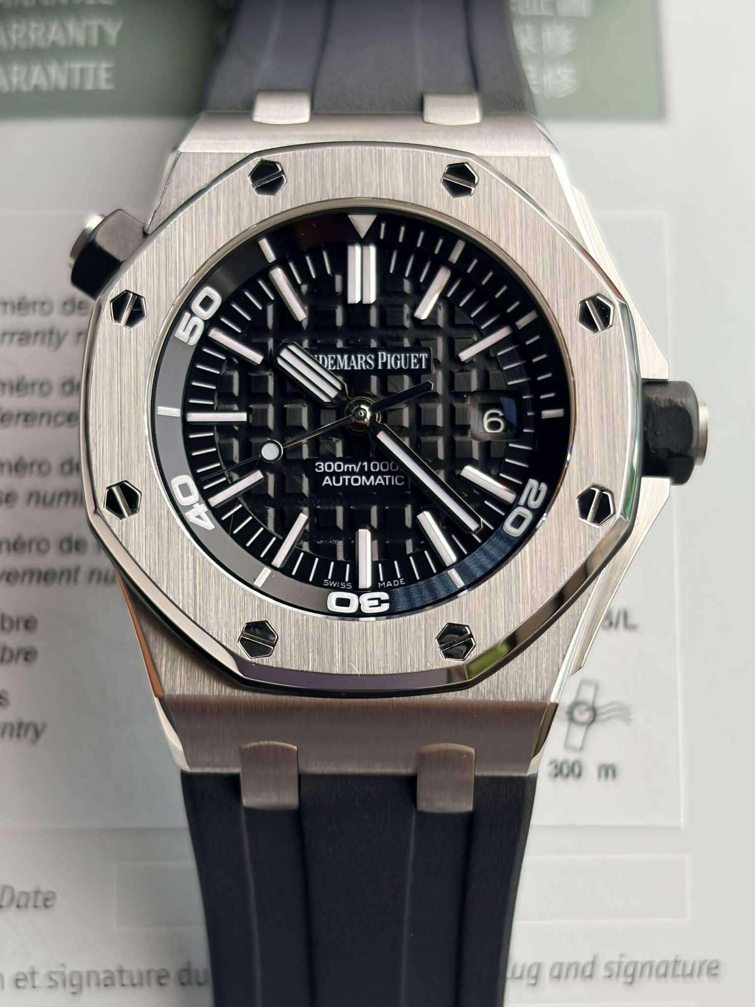 May be an image of wrist watch and text that says 'RRANTY RANTIE nero de rranty néro rence DEMARS DEMARSPIGUET DEM PIGUET ET 6 300m/ 300ml AUTOMATIO O0 0c AUTOMAT néro.d num érode…