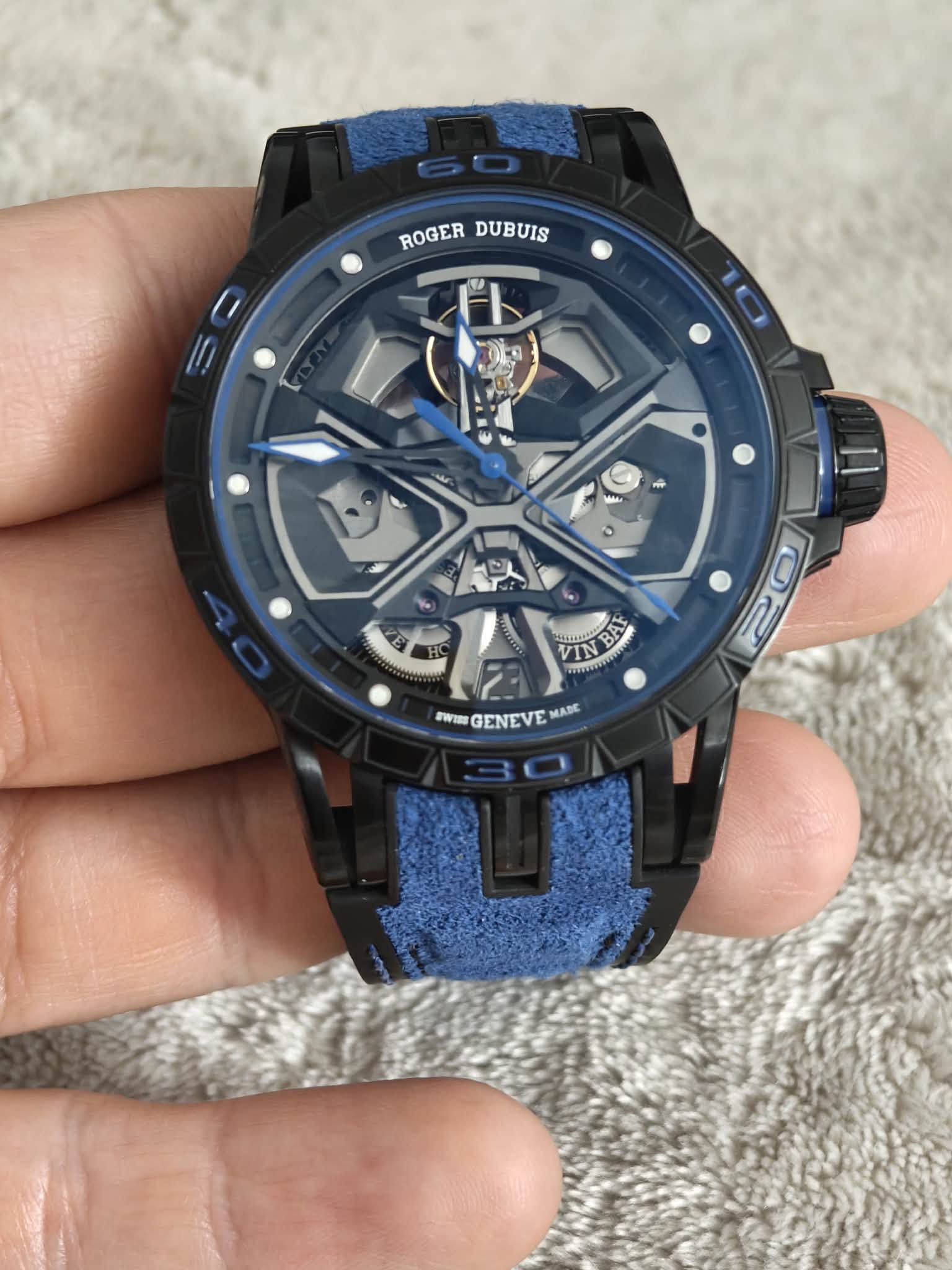 May be an image of digital watch and text that says 'ROGER ROGERDUBUIS DUBUIS OE 2 BAY ""ល0 PNWGENEVEMAK TWI GENEVE MABC'