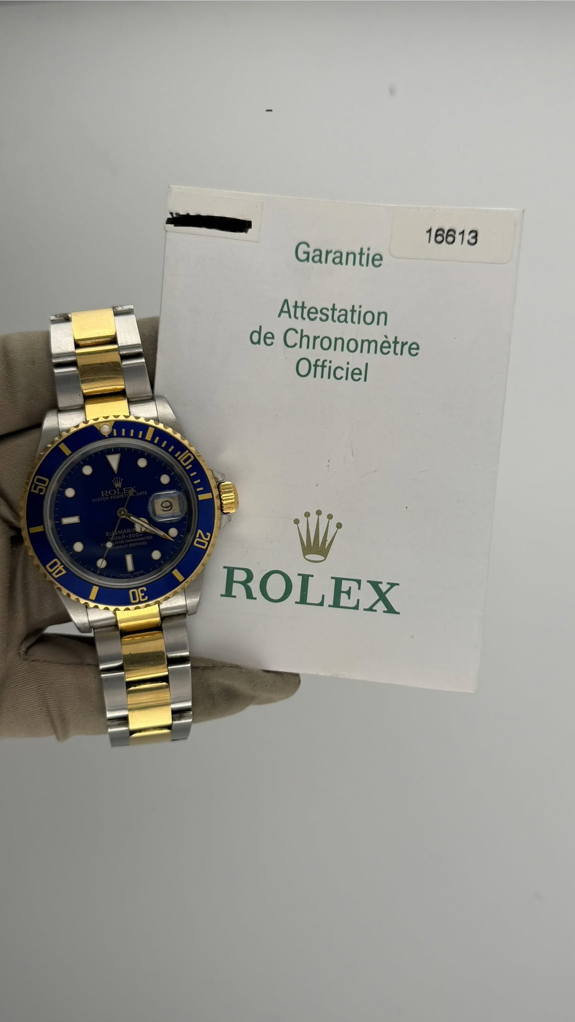May be an image of wrist watch and text that says '16613 Garantie Attestation de Chronomètre Officiel ROLEX'
