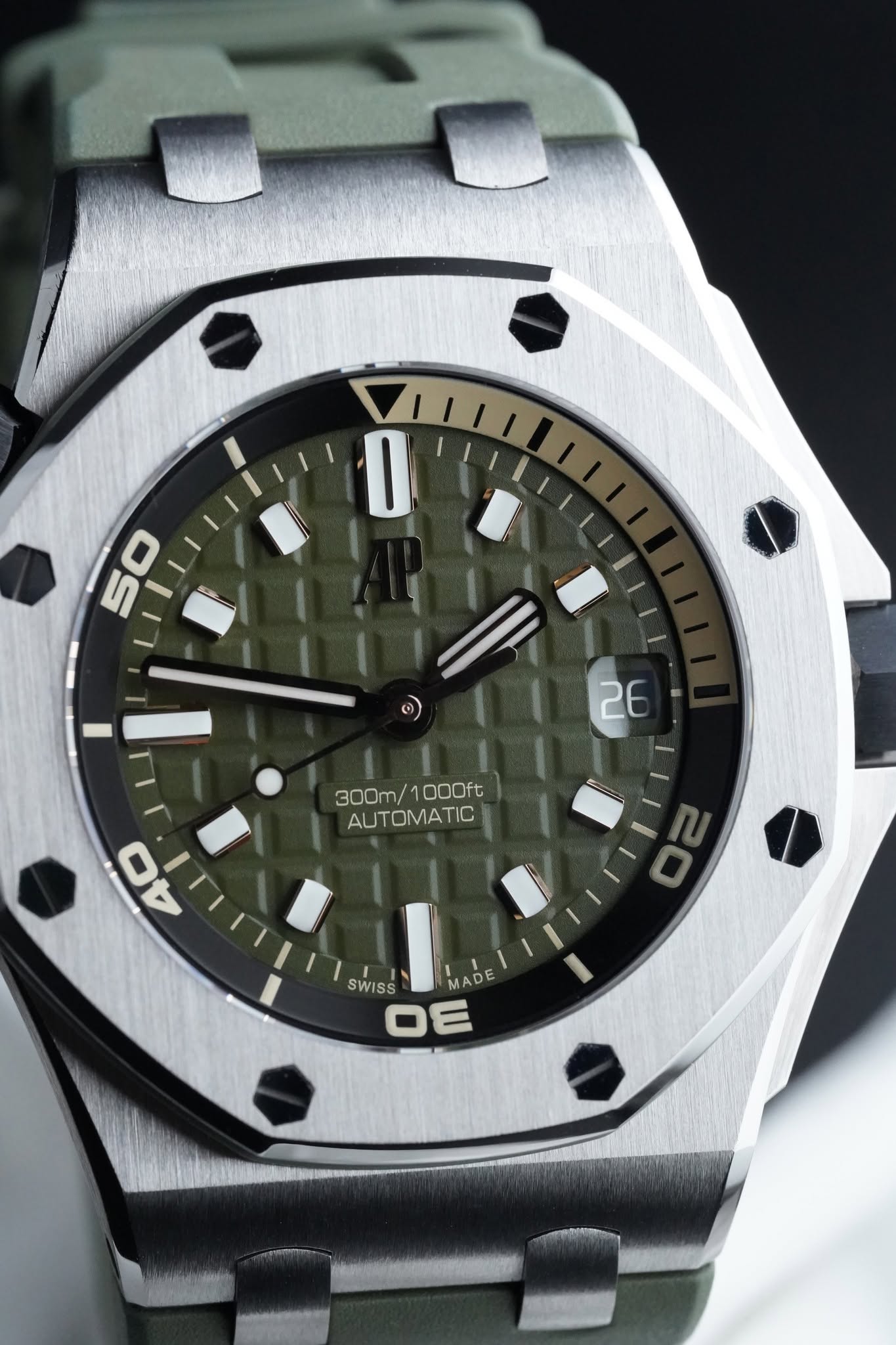 May be an image of wrist watch and text that says 'I 26 300m/1000ft 300m/ 1000ft AUTOMATIC 40 SWISS MADE OE'
