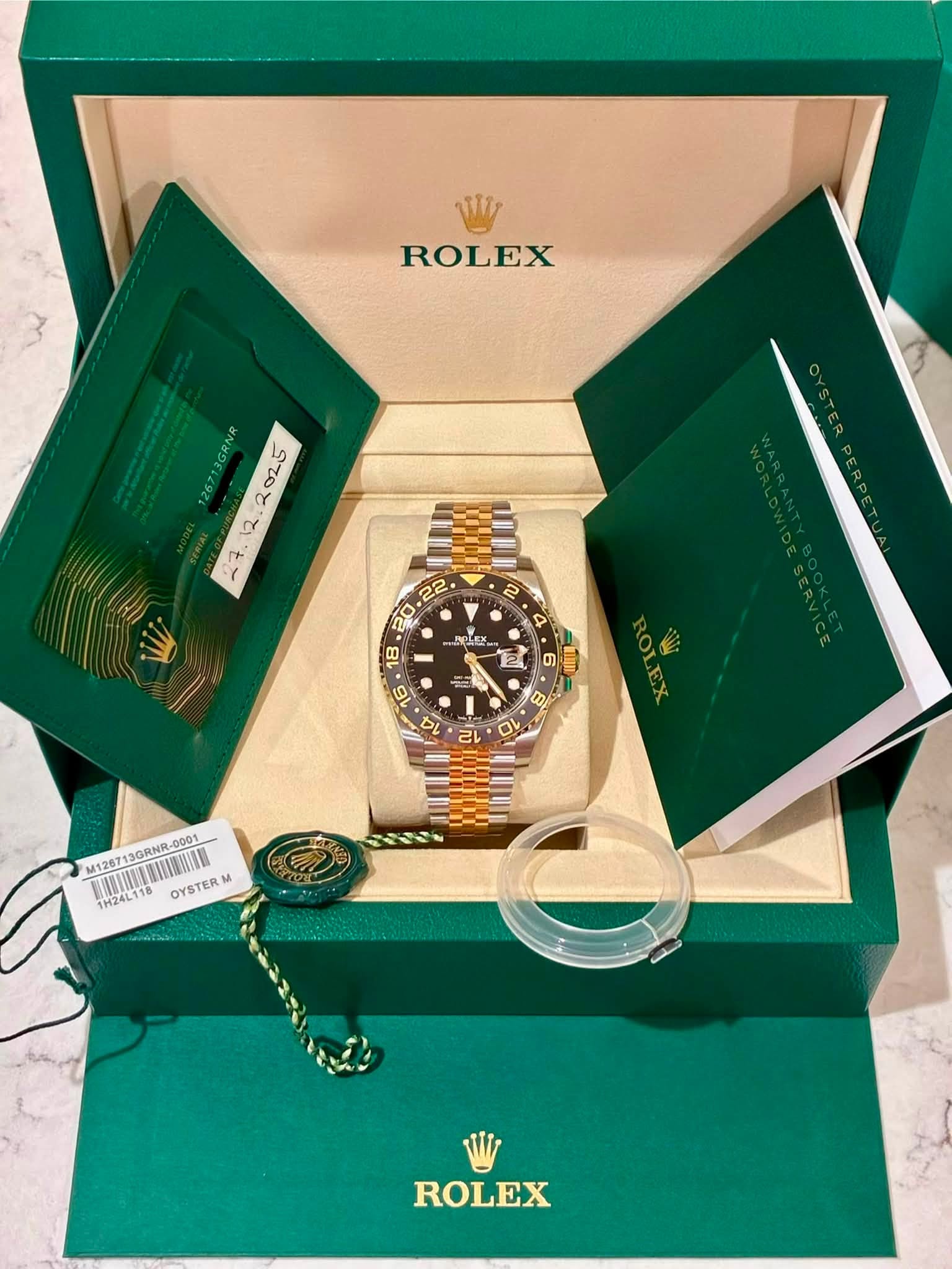May be an image of wrist watch and text that says 'ROLEX 26713GRNR ف٠ 2 22 20 ก 8 PLEX EK 2 6 T 16 百 194 בי 0 M126713GRNR-00 M1267 13GRNR- -0001 1H24L118 OYSTERM ROLEX'