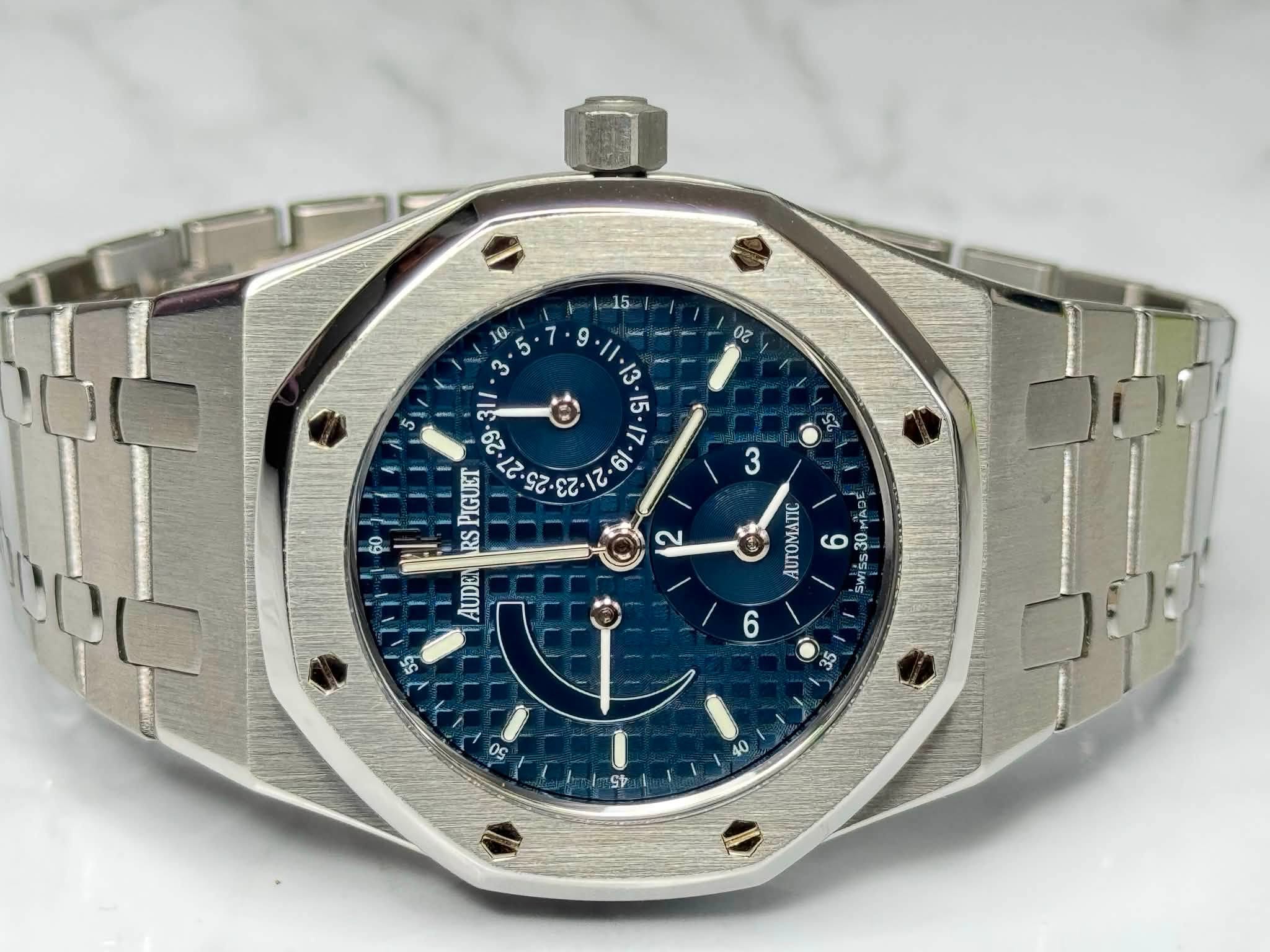 May be an image of wrist watch and text that says ' ጃ CUR PIGUET RS AUDEN a E0 3 AUTOMATIC 6 30 2OV MAD 30 SWISS 0C Sp'