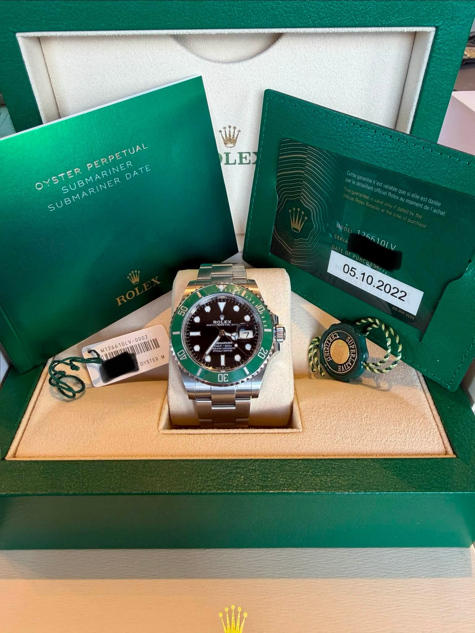 May be an image of wrist watch and text that says 'LE PERPETUAL RINER DATE OYSTER SUBMARINER SUBMARINER ooTB- SUBMA 50 ኢቃባ 10 ROLEX 26610LV M126610LV 服頭造即信 mgc OYSTER 07 7 2 3E'