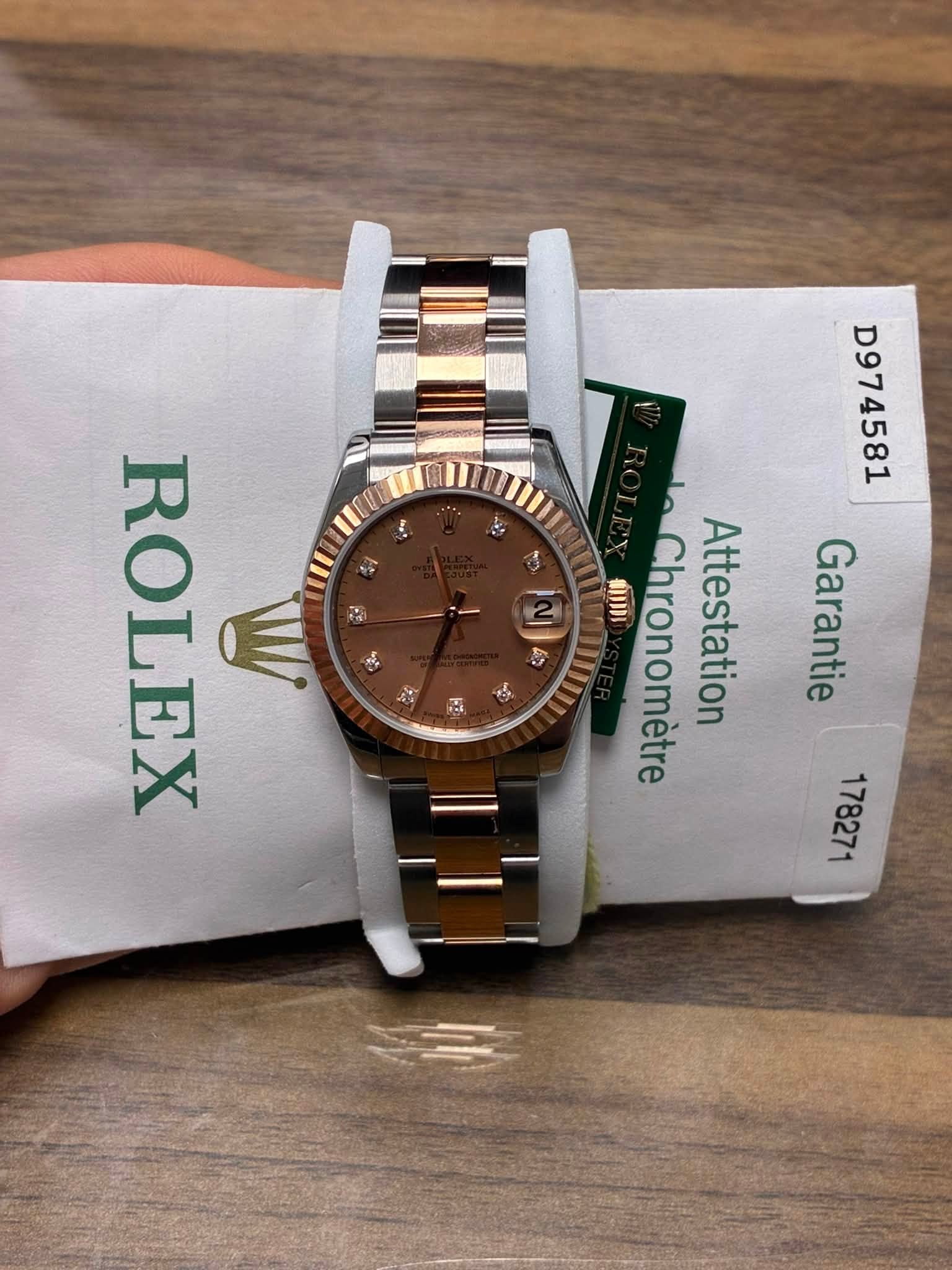 May be an image of wrist watch and text that says 'E D974581 ん 4s こ लি) ภาาาม ل2 Chronomètre Cestati Hestation Garantie Attestation ROLEX'
