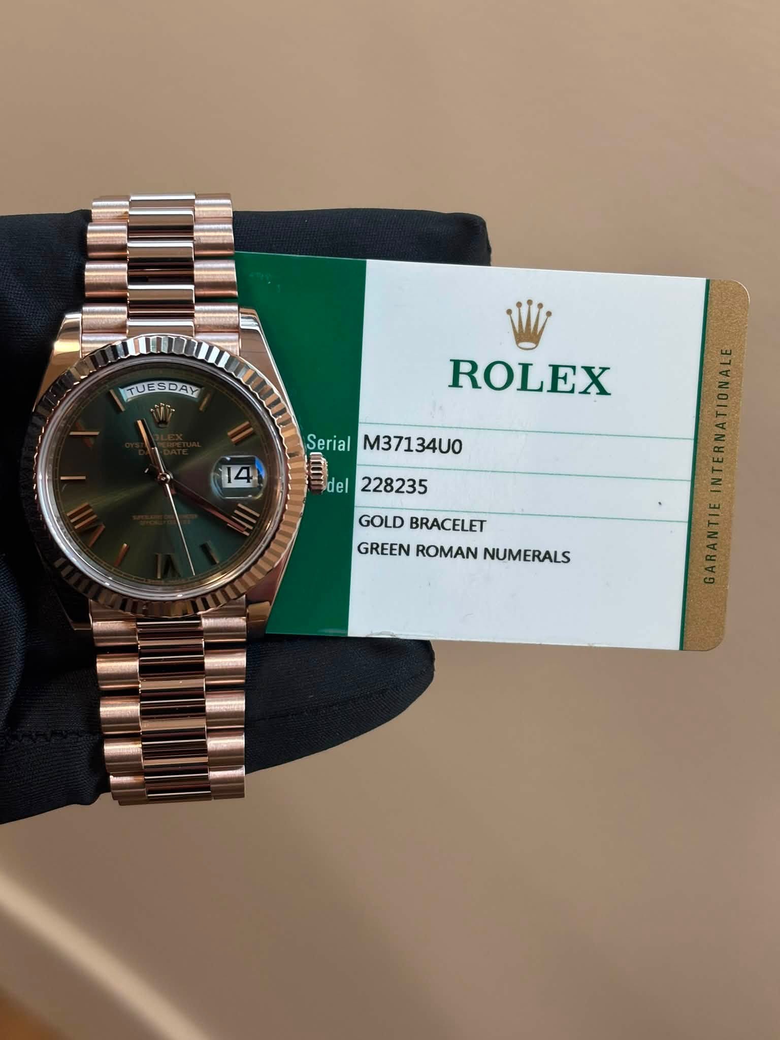 May be an image of wrist watch and text that says 'TUESDAY ROLEX 14 4 Serial M37134U0 = del 228235 GOLD GOLDBRACELET BRACELET GREEN GREENROMAN ROMAN NUMERALS'