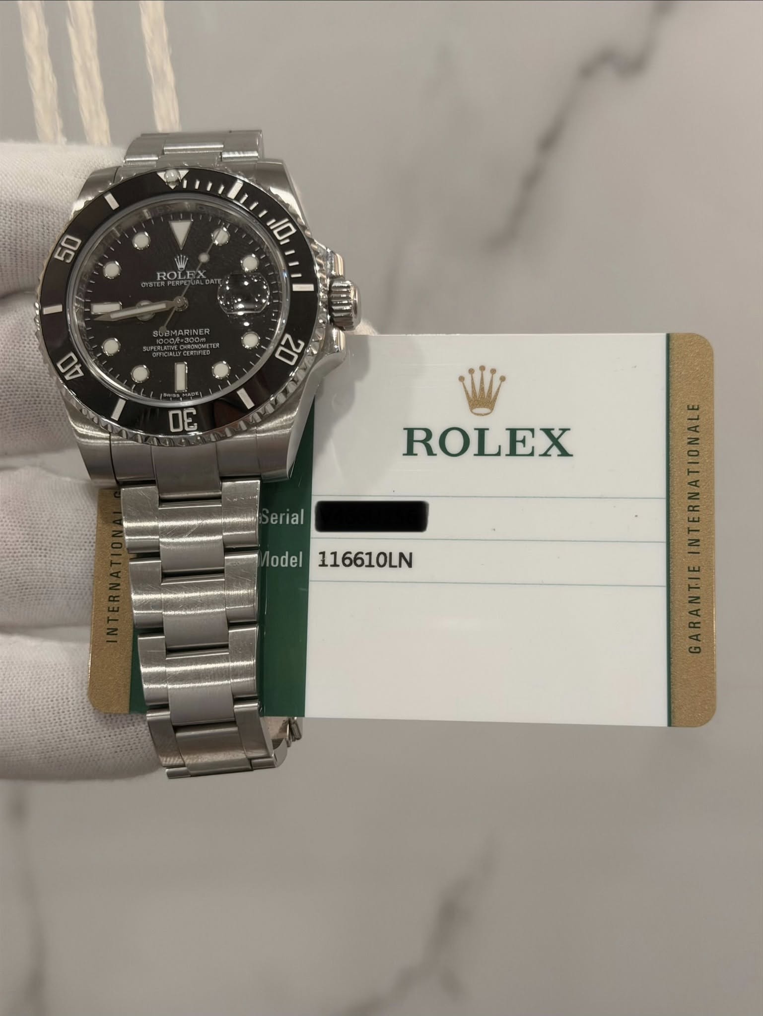 May be an image of wrist watch and text that says '50 10 ROLEX CEMARINER 40 20 DE ROLEX erial ΘΓι a odel 116610LN อ W:H'