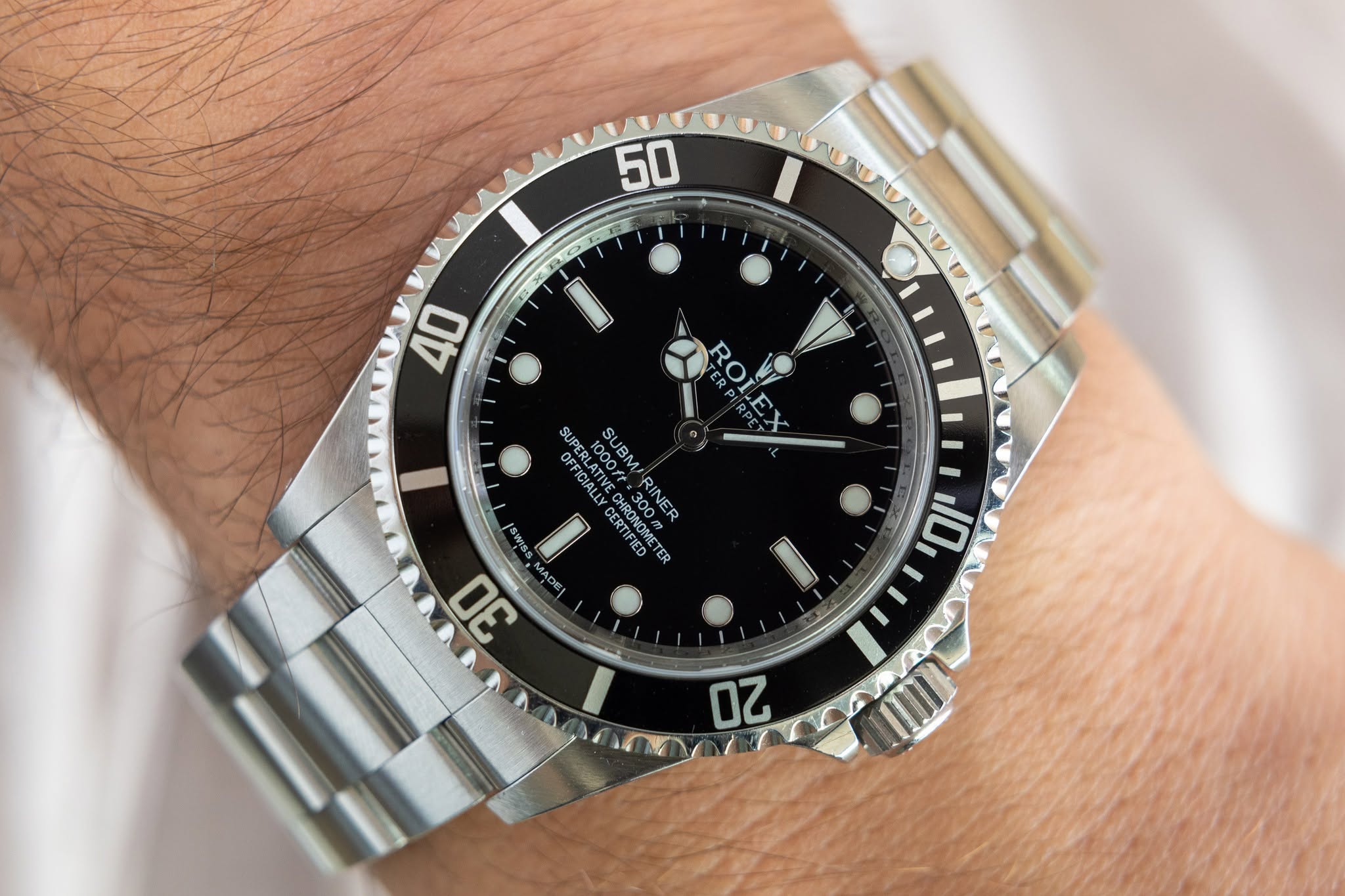 May be an image of wrist watch and text that says '50 40 A OFFICIALLY SUPERLATIVE 100M SUBMARINER 1000ft SUBM SUPERLATI SWISS CERSNON CERTIFIED CSSNOMETER =300m MOOS AHOPO RONEO…