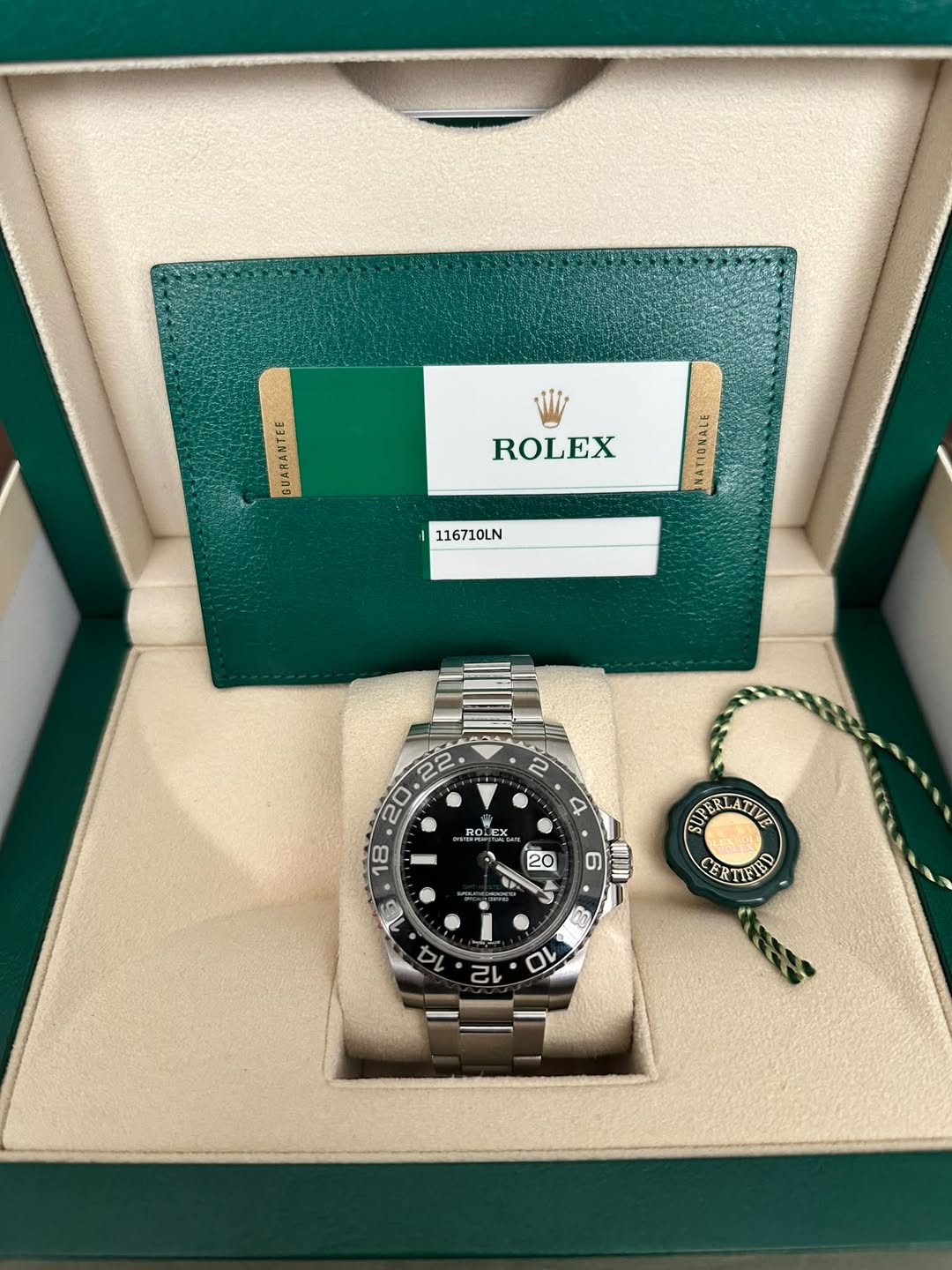 May be an image of wrist watch and text that says '331ะตกร ROLEX 116710LN a. E E 9 20 N K ۲ ្ច្លា APERLATITE ELATIVE CERTIETD CER ITFIED 16 4 0 ባ'