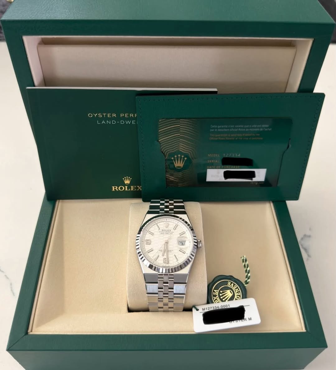 May be an image of wrist watch and text that says 'OYSTER PERF OYSTERPERF E AND-DWE WW ROLE 馬 9 आ ۹ز Gj SX II מהממאה ANES M1273 M127134 -0001 OTERM M'
