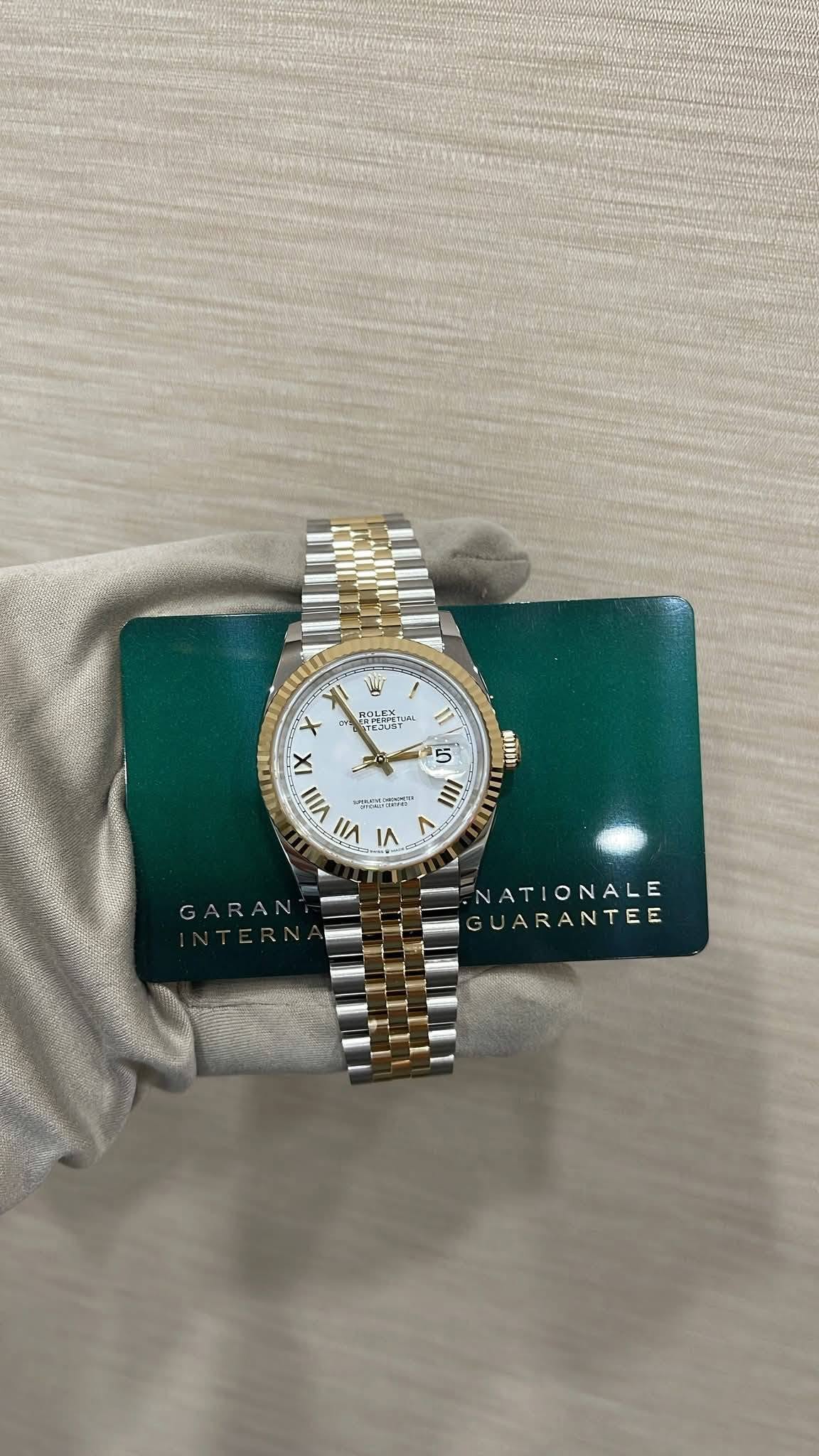 May be an image of wrist watch and text that says 'آلیا T 6 KOT အ X VIII VII LT 5 和山 III LUT L GARAN ATIONALE ARANTEE'
