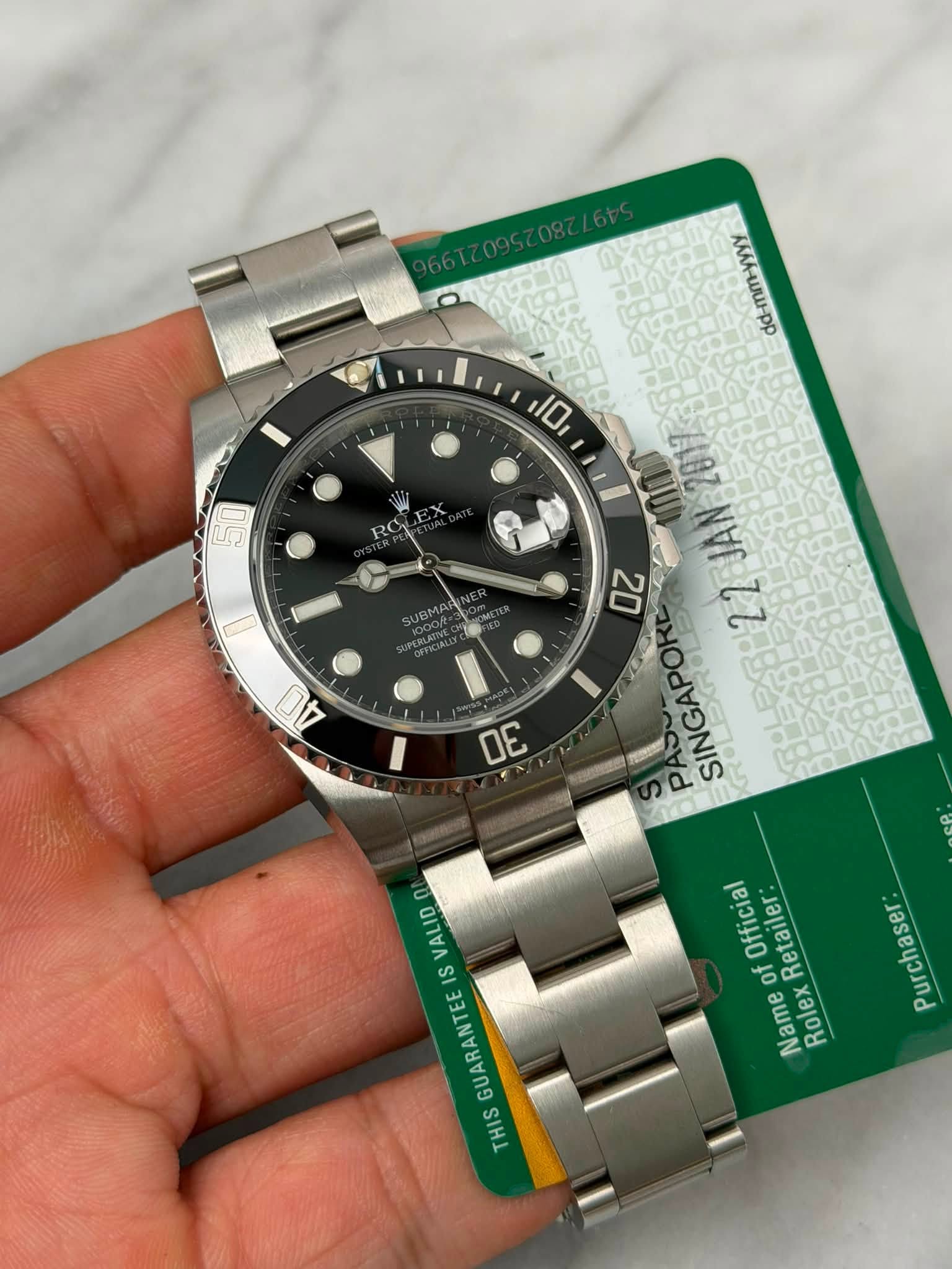 May be an image of wrist watch and text that says 'dd-mm-yyyy นว JBMA 40 10 0Z FAS 間是発:22JAN JAN 26ะ22 22 ンー SINGAPORE OE 0 VALID IS GUARANTEE THIS Official of Retailer: Name Rolex…