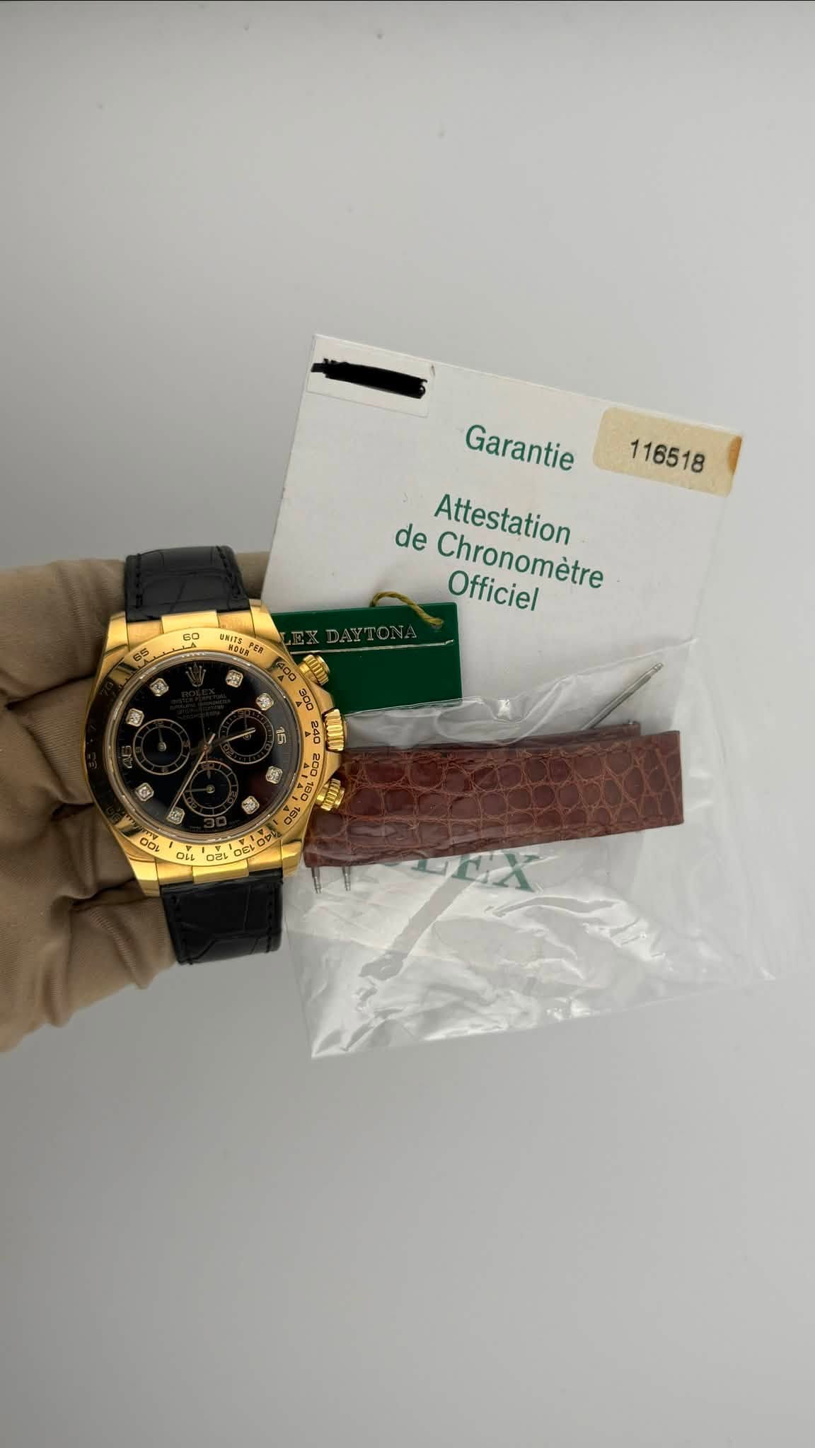 May be an image of wrist watch and text that says '116518 Garantie Garantie de Attestation Chronomètre Officiel SNITETLR 4 08'