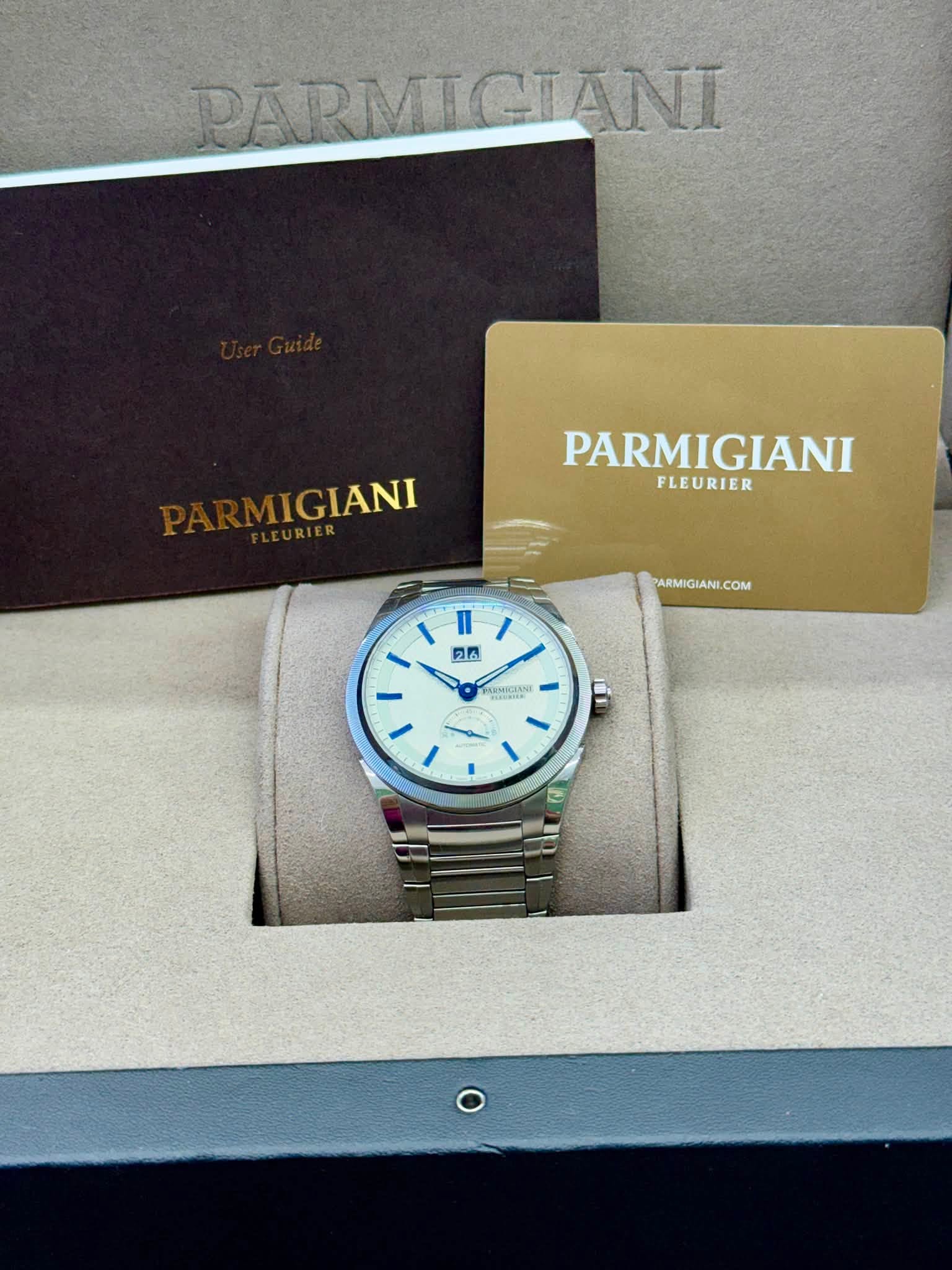 May be an image of wrist watch and text that says 'PARMICIÃNI MIGIANI PARMIGIANI FLEURIER PARMIGIANI.COM PARMIGIAN I n I 26 1 3'