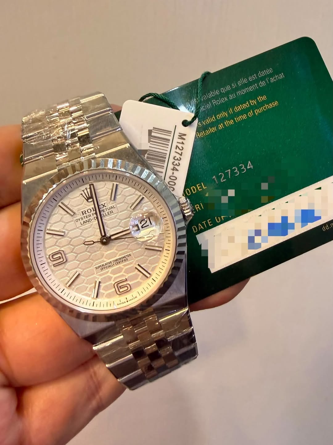 May be an image of wrist watch and text that says 'elle est datee achat diaure aiable quesi aumomento au Aclel Rolex မုင့် dat datedby πν m127334-00R ODEL Retailer alid at the tme…