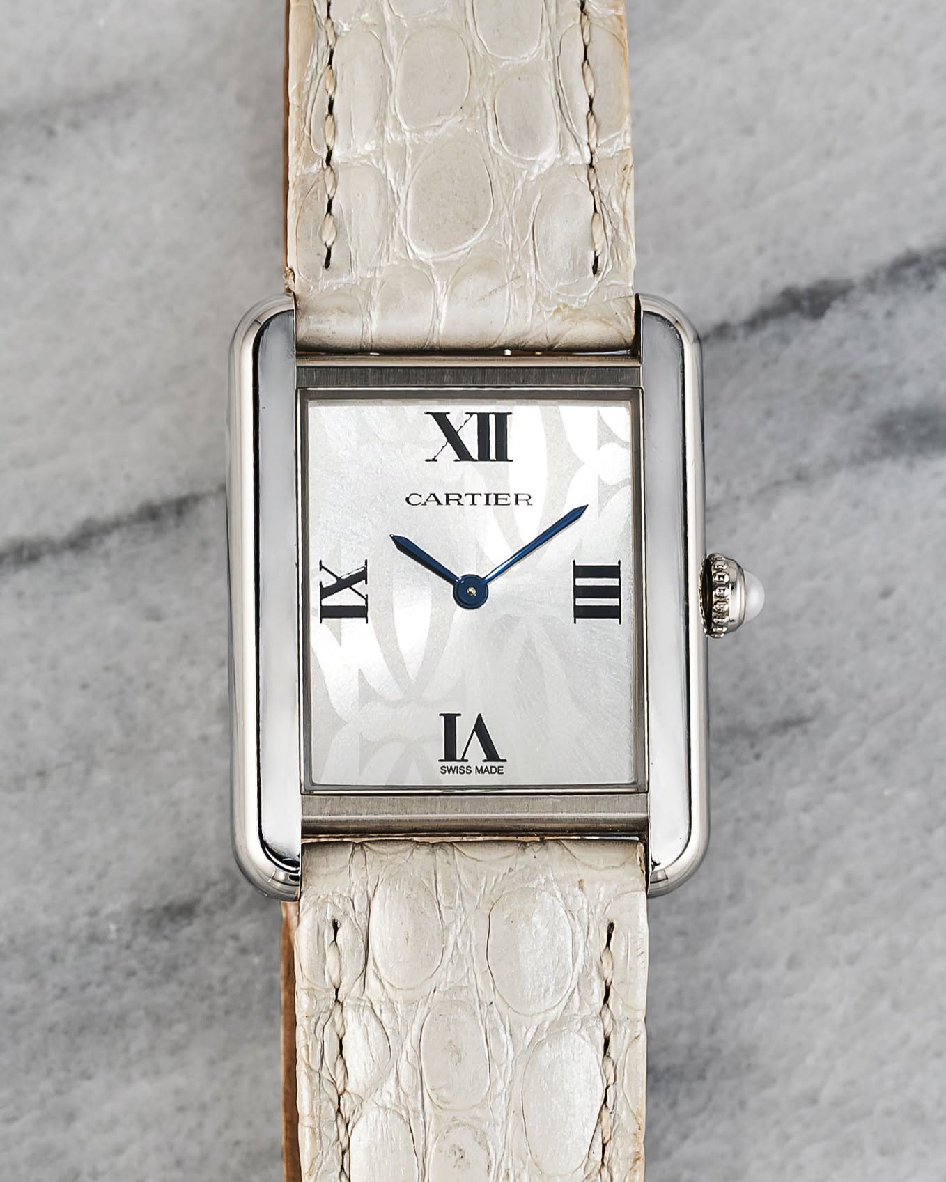 May be an image of leather, wrist watch and text