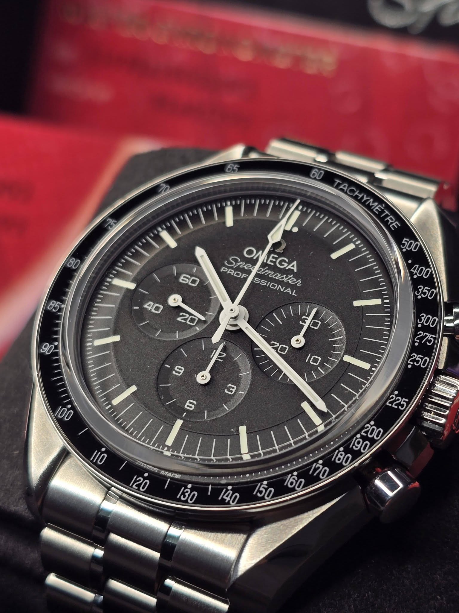 May be an image of wrist watch and text that says ' TACHYMÈTRE RE PROF She PROFESSIONAL OF OMEGA epodmaster SSIC SSIONAL 40 20 80 U LO 20 C 300 £ ယ ወ 100 225 สมชร ၁ 120 MADE เดิ '