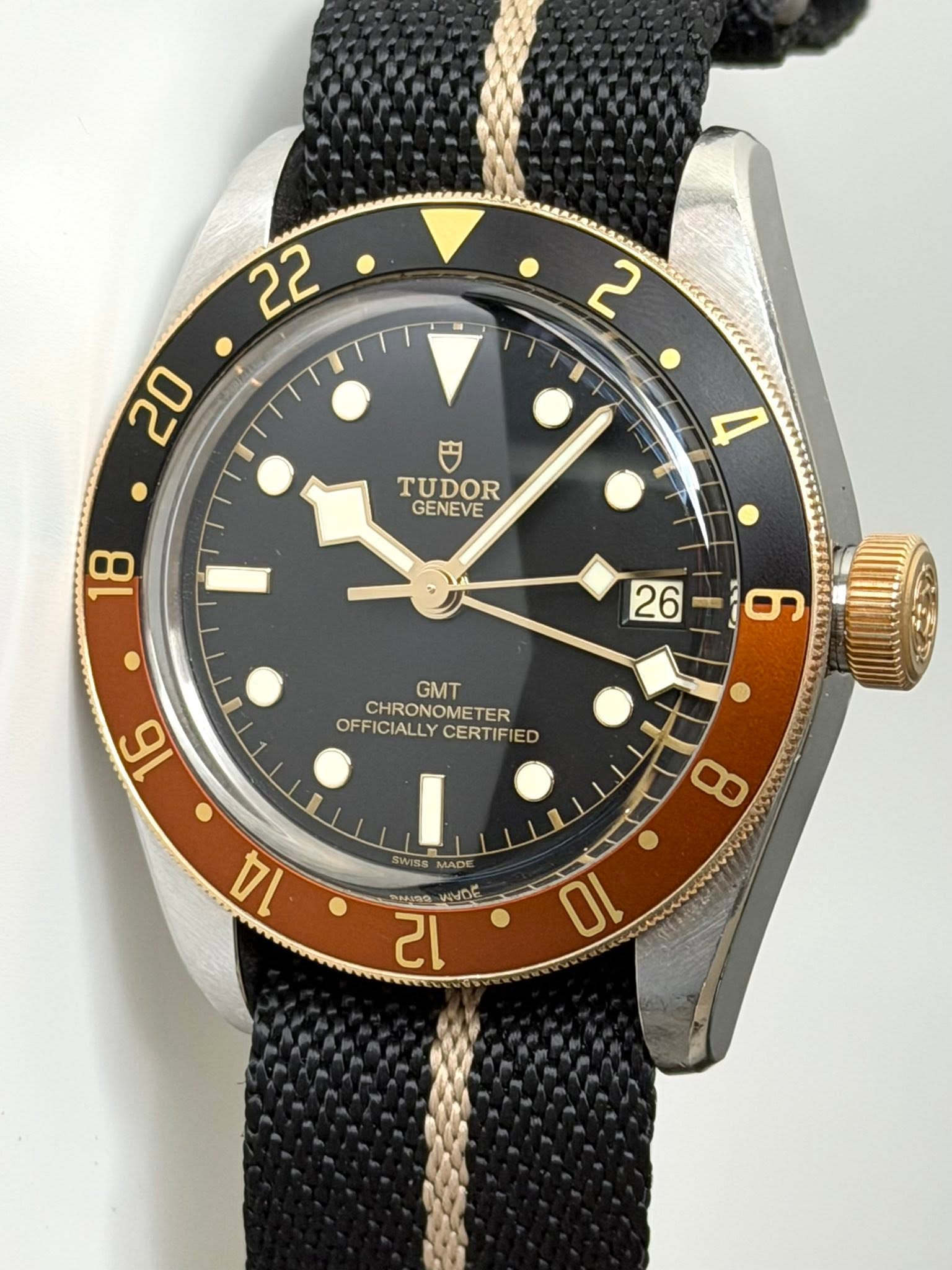 May be an image of wrist watch and text that says '22 2 20 円 TUDOR GENEVE 水 و 26 16 GMT CHRONOMETER OFFICIALLY CERTIFIED OFFICIALLYCERTIFIED CERTI I SWISS MADE '
