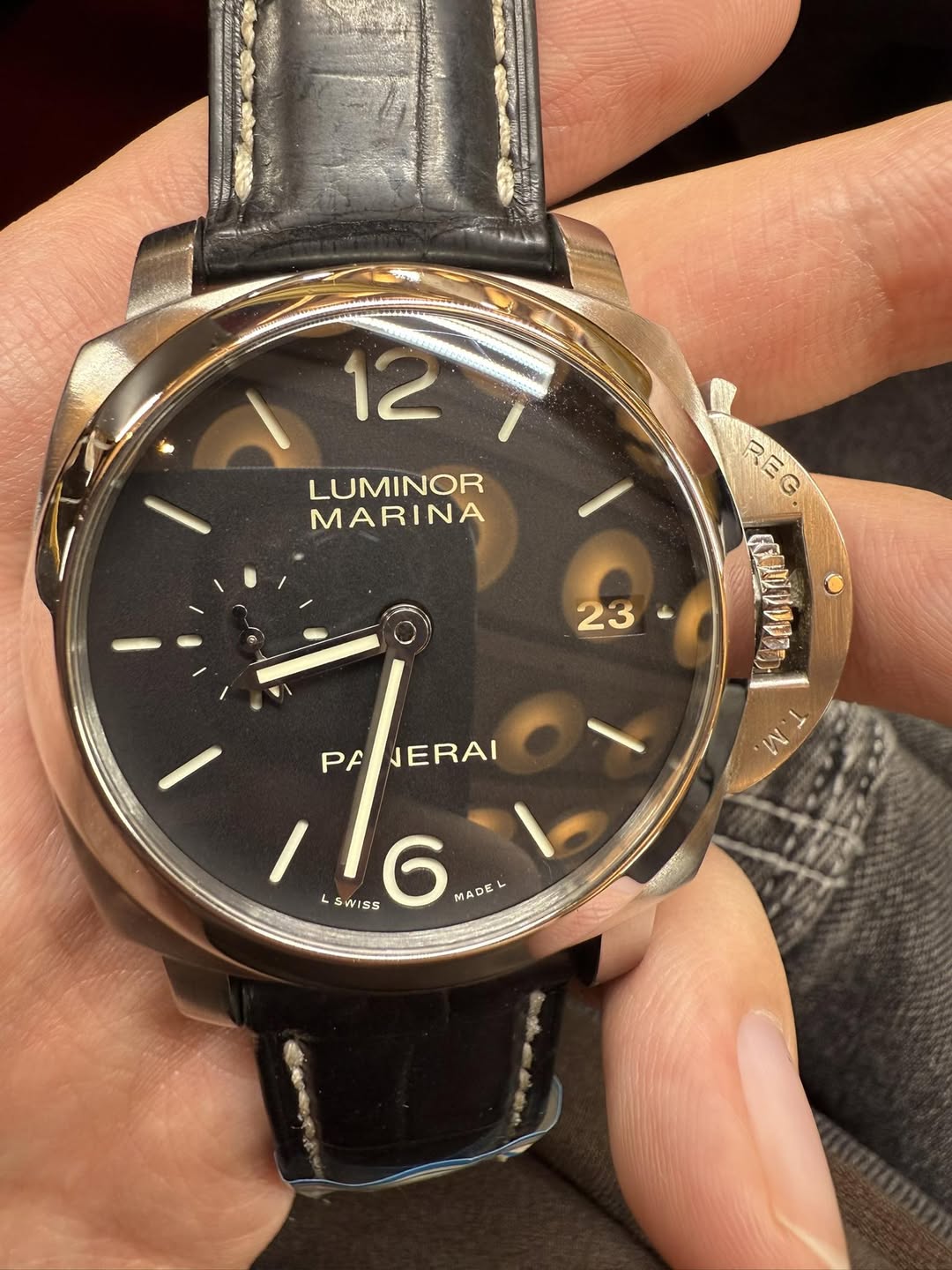 May be an image of wrist watch and text that says '12 LUMINOR MARINA REG 23 ن I PF NERAI LSWISS 16 WIS VISS L WISS MADE'