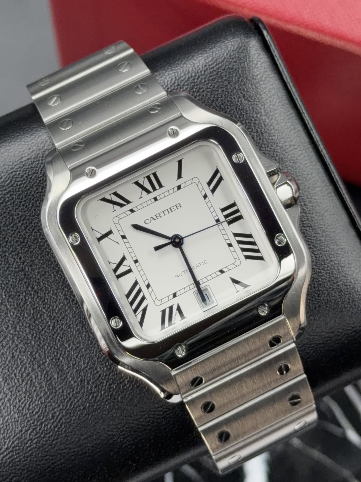 May be an image of wrist watch and text that says 'I O II XI XII IIII CARTIER III X LITT T 6 IX CILI VII VI ATIC AUT'