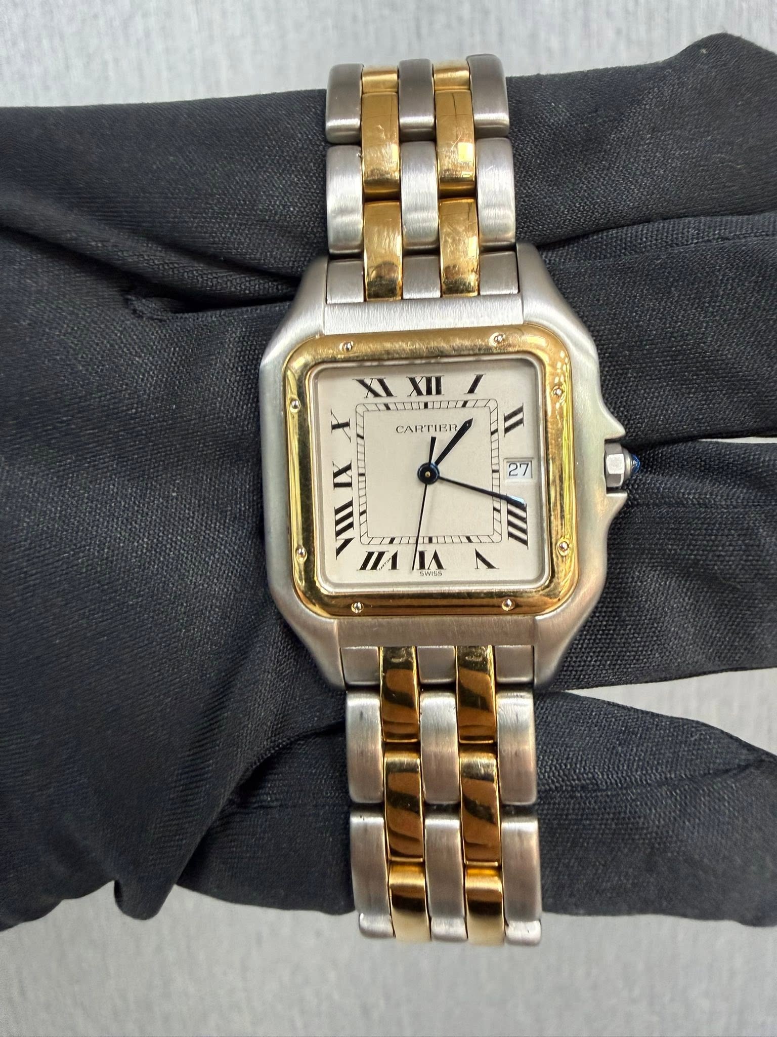 May be an image of wrist watch and text that says 'XI XIXII XII INITTLE CARTIER 27 IX VIII TEEL EILLY И nAЛA ٨ IA 4'
