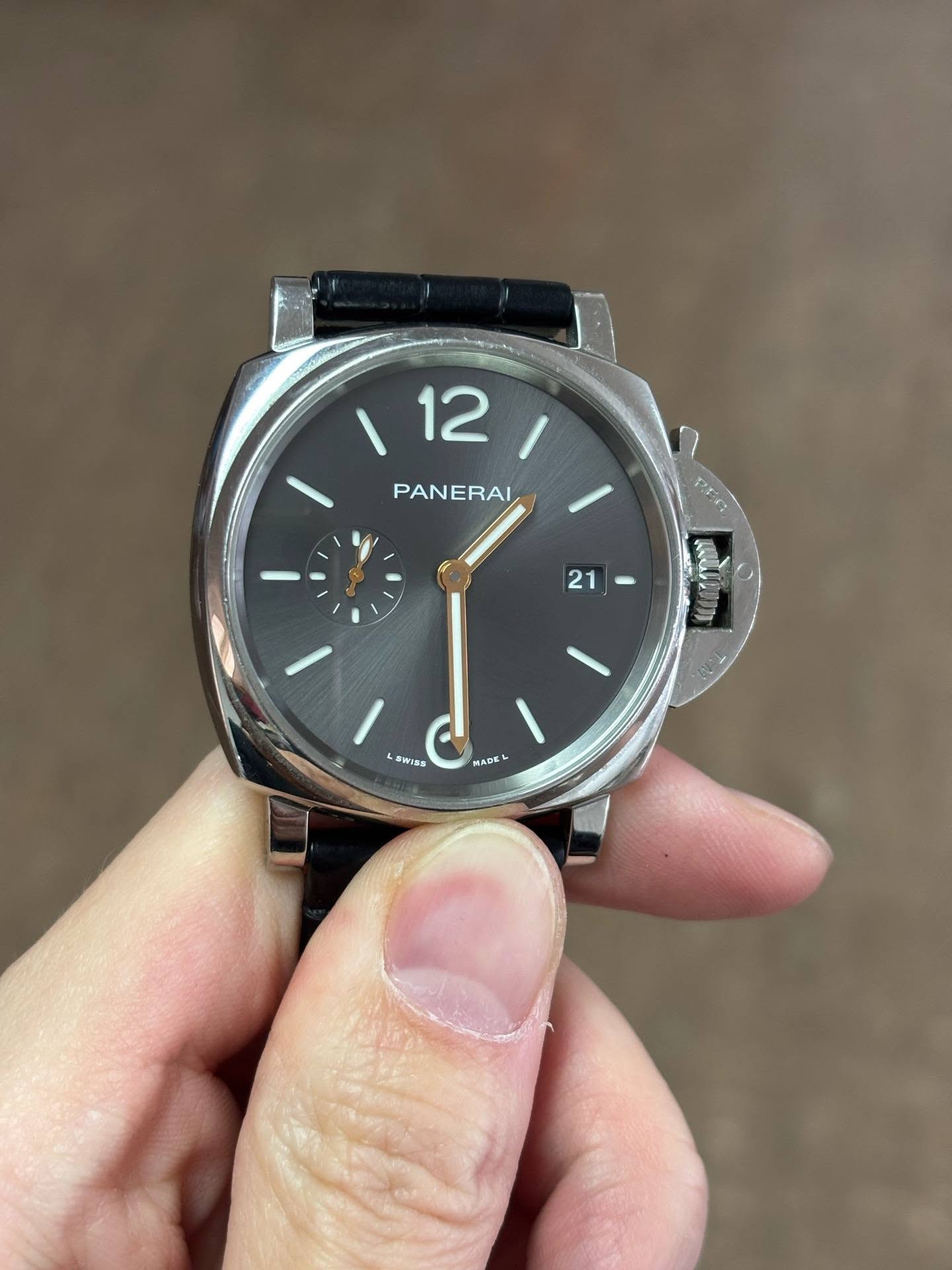 May be an image of wrist watch and text that says '/211 12 PANERAI 21 - SWISS Wiss MADE'