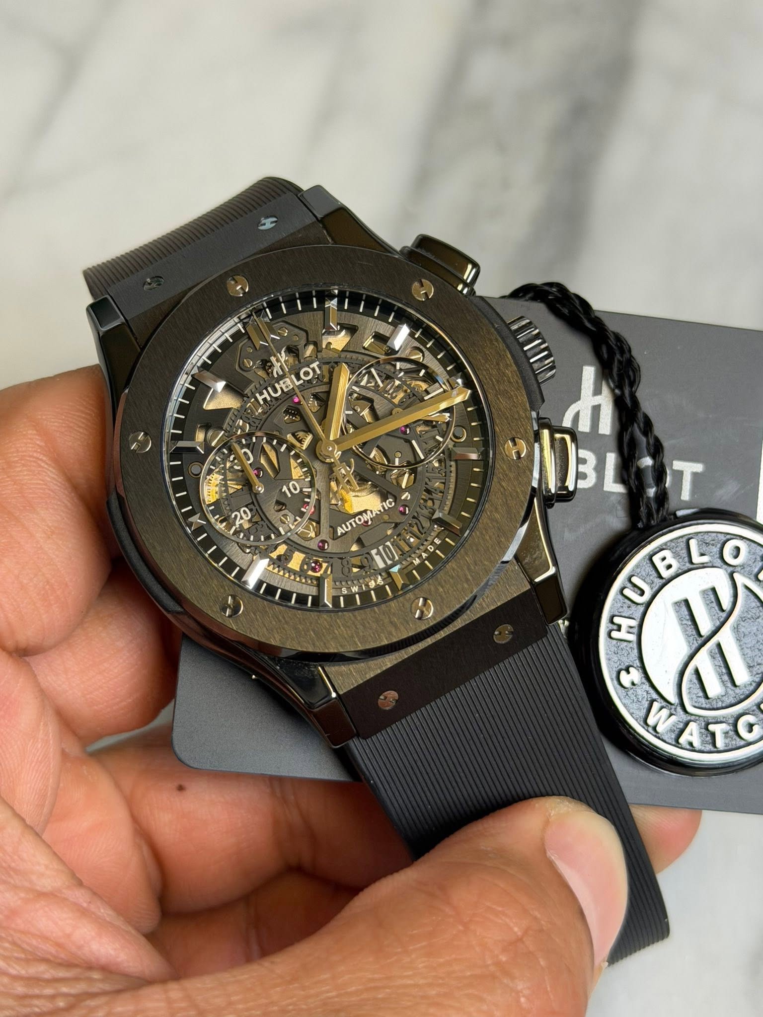 May be an image of digital watch and text that says 'HUBLOT HUBLOT 10 0 TIC 1I t 3L BLIT - T ዲስበ T د B WATC y'