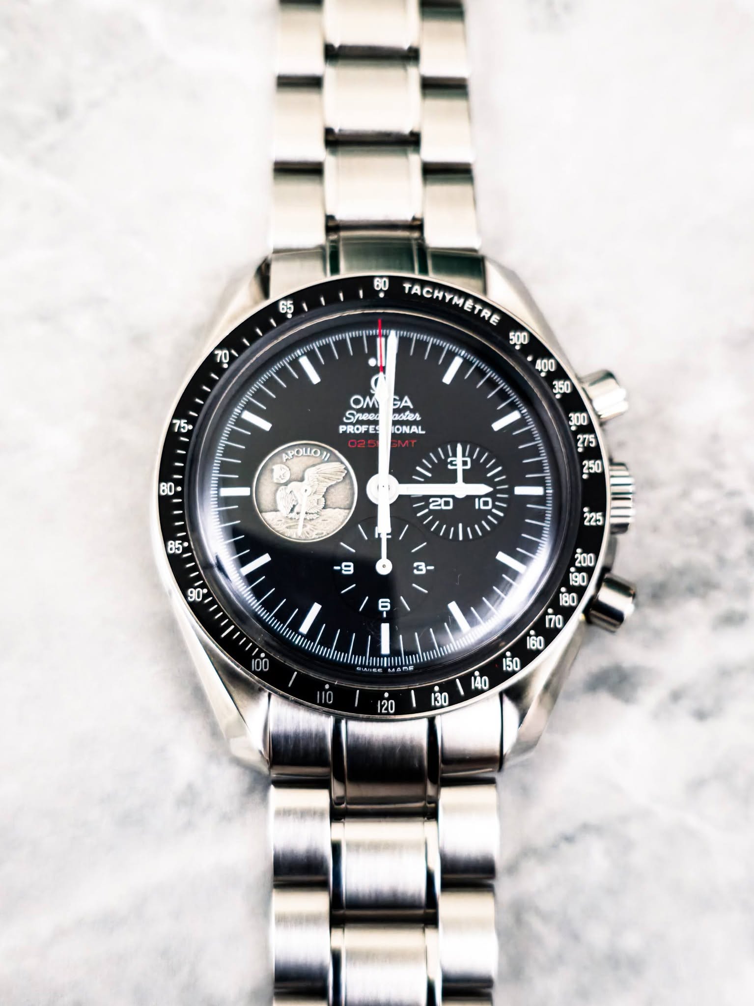 May be an image of wrist watch and text that says '65 0 60 TACHYMETRE TACHYMETRE T ဟ OM GA Boten PROFE IONAL APOLLO G5 20 10 ပိ့ iRD n0 BIm 120 30 तप'