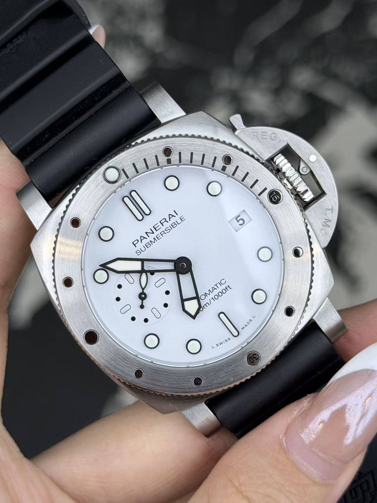 May be an image of wrist watch and text that says 'REG O UEDODENEN O O I 5 4 T.M 1I O O PANERAI SURMERAI SUBMERSIBLE 0m/1000ft m OMATIC MADE 0 4 S WiSs iss'