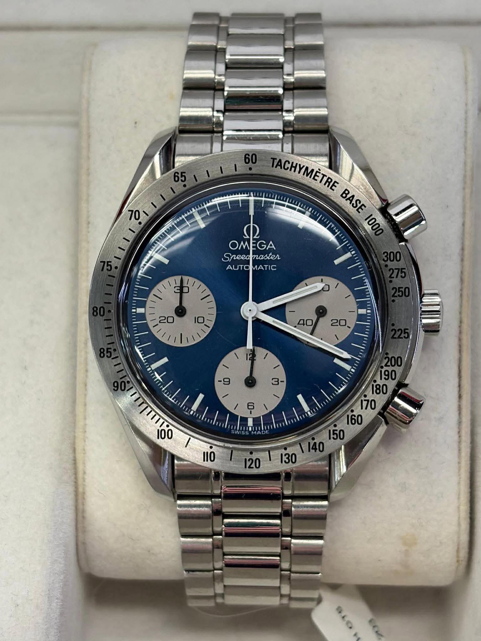 May be an image of wrist watch and text that says 'ا 65 1II TACHYMÈTRE BASE 10 社 100 ب OMEGA Sreeamaster GA OM Speea Sreeamaster naster AUTOMATIC TI C AU yC 3 10 20 TT E SLO'