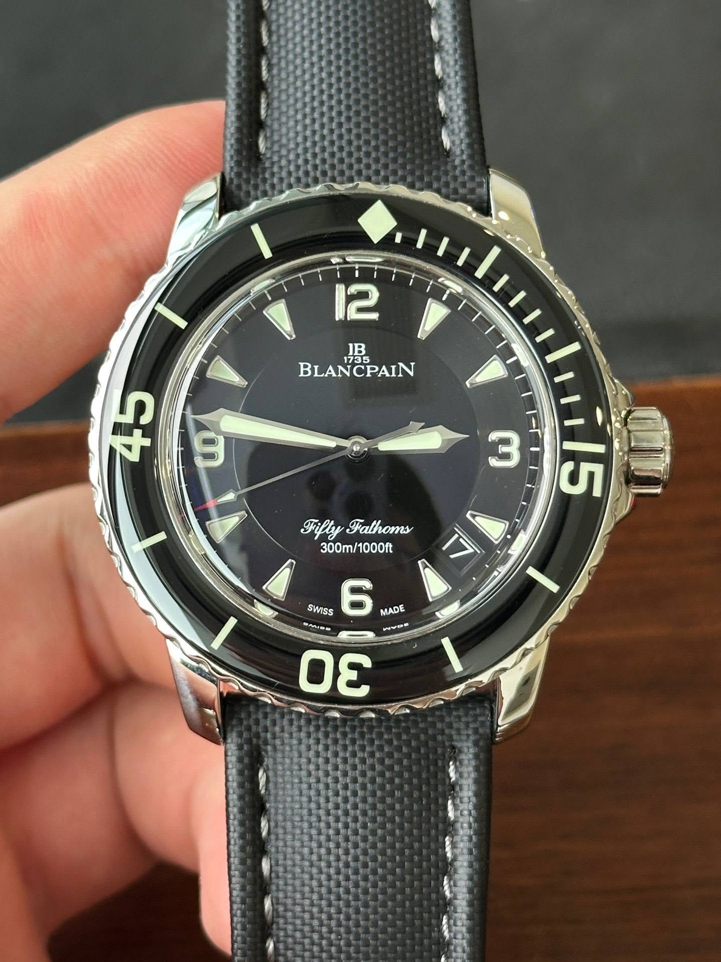 May be an image of wrist watch and text that says '12 V 1 1B BLANCPAIN BLA PAIN 新 9 X Fifly FiflyFathoms Fathoms 300m/1000ft /1000ft ኢ 5 Q 1l5 SWISS 6 MADE pH mwoR 3 mma /'