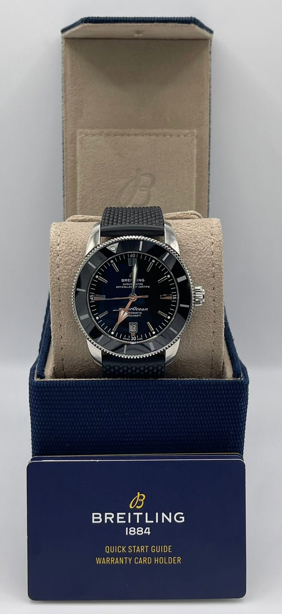 May be an image of wrist watch and text that says 'BB BREITLING 1884 QUICKSTARTGUIDE QUICK ART UIO WARRANT CARD CARDHOLDER WARRANTYCARDHOLDER HOL DER'