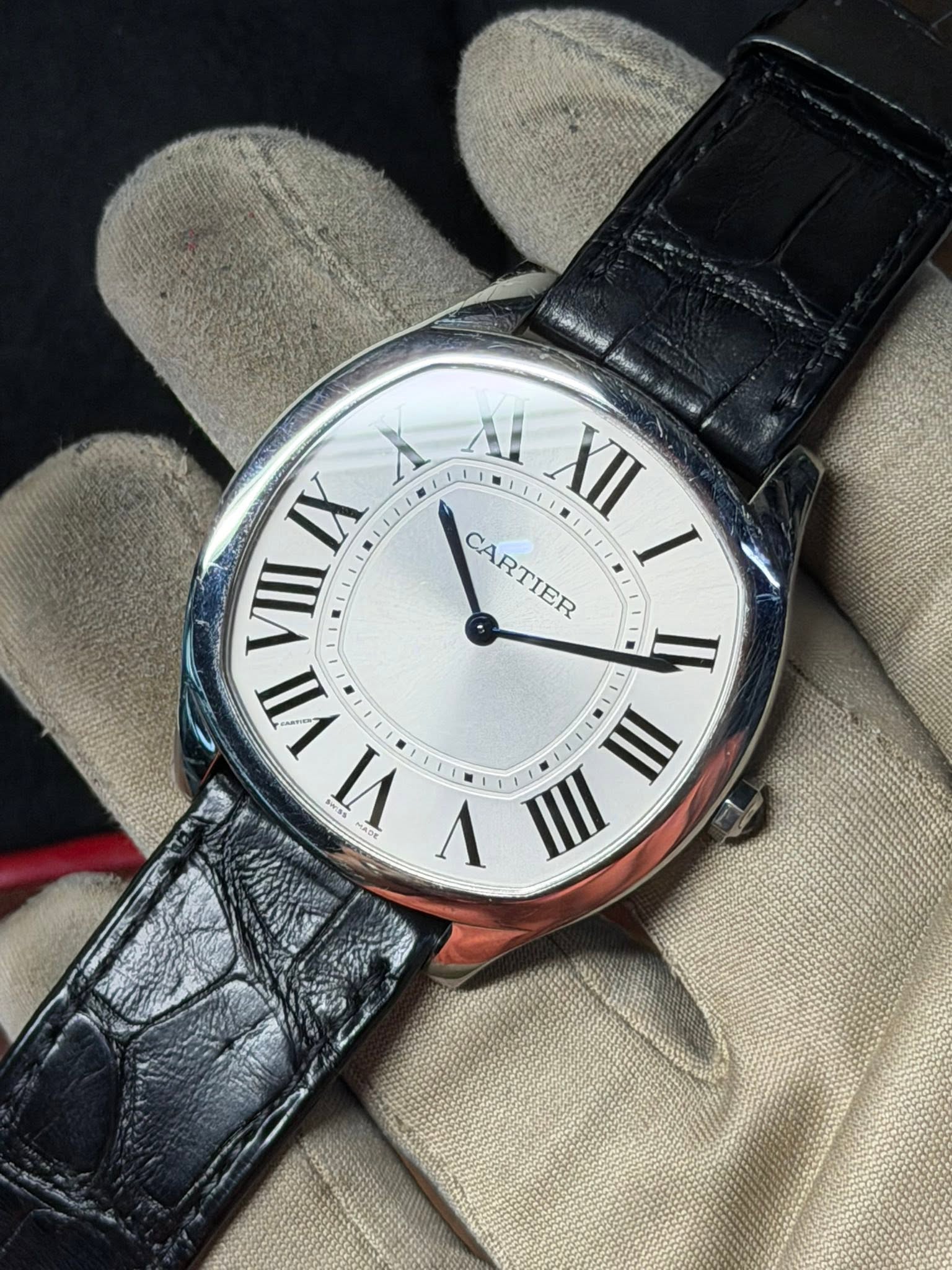 May be an image of wrist watch and text that says '09小 SPat A XII IX VIII CARTIER I I VII VII VI V 1 II'