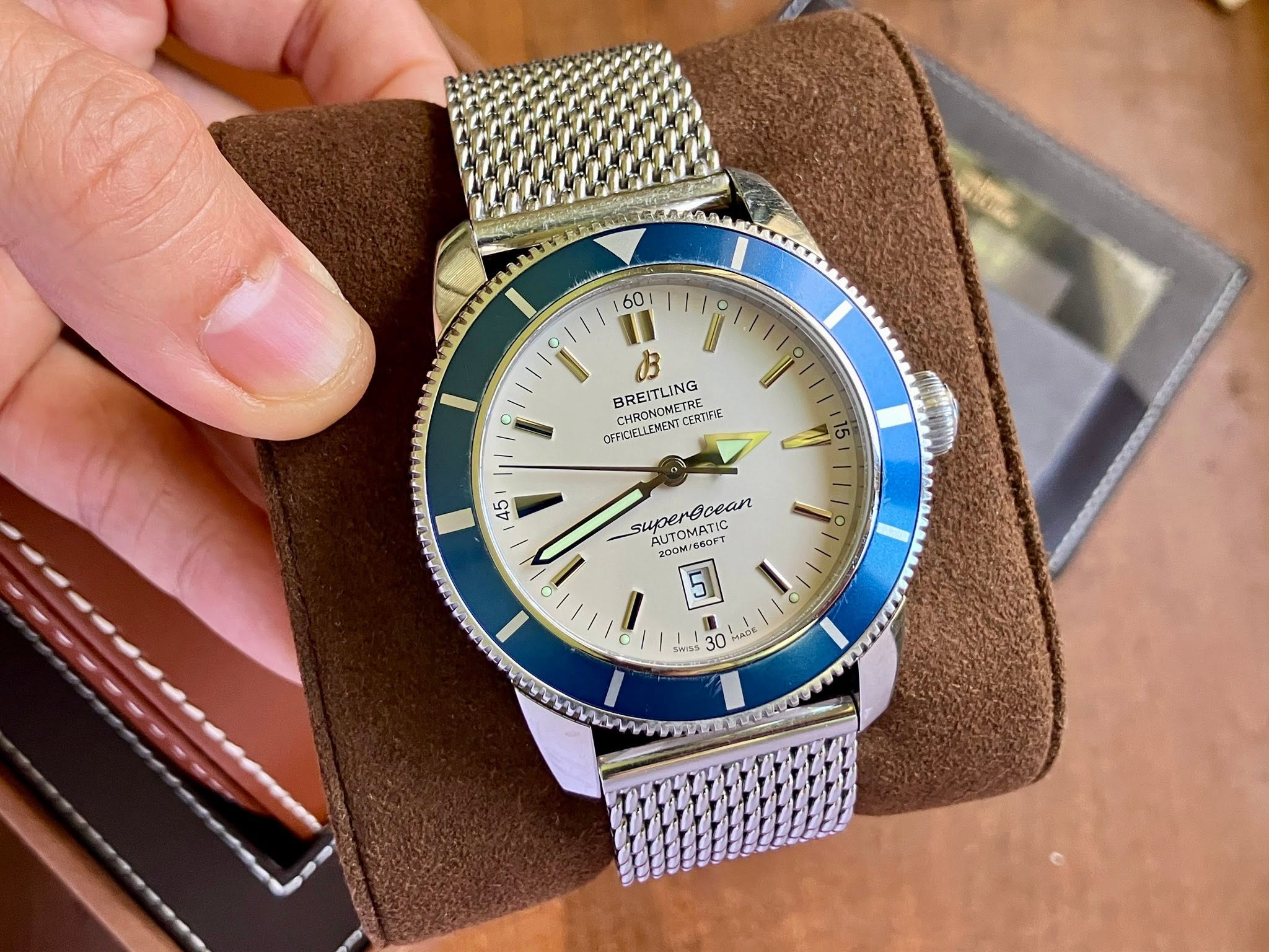 May be an image of wrist watch and text that says '60 I u BREITLING HRONOMETRE CERTIFIE OFFICIELEMENT.CERTIFIE FIC/ELLEMEN 45 super BOCAM AUTOMATIC superGoean supereoean 660FT A…