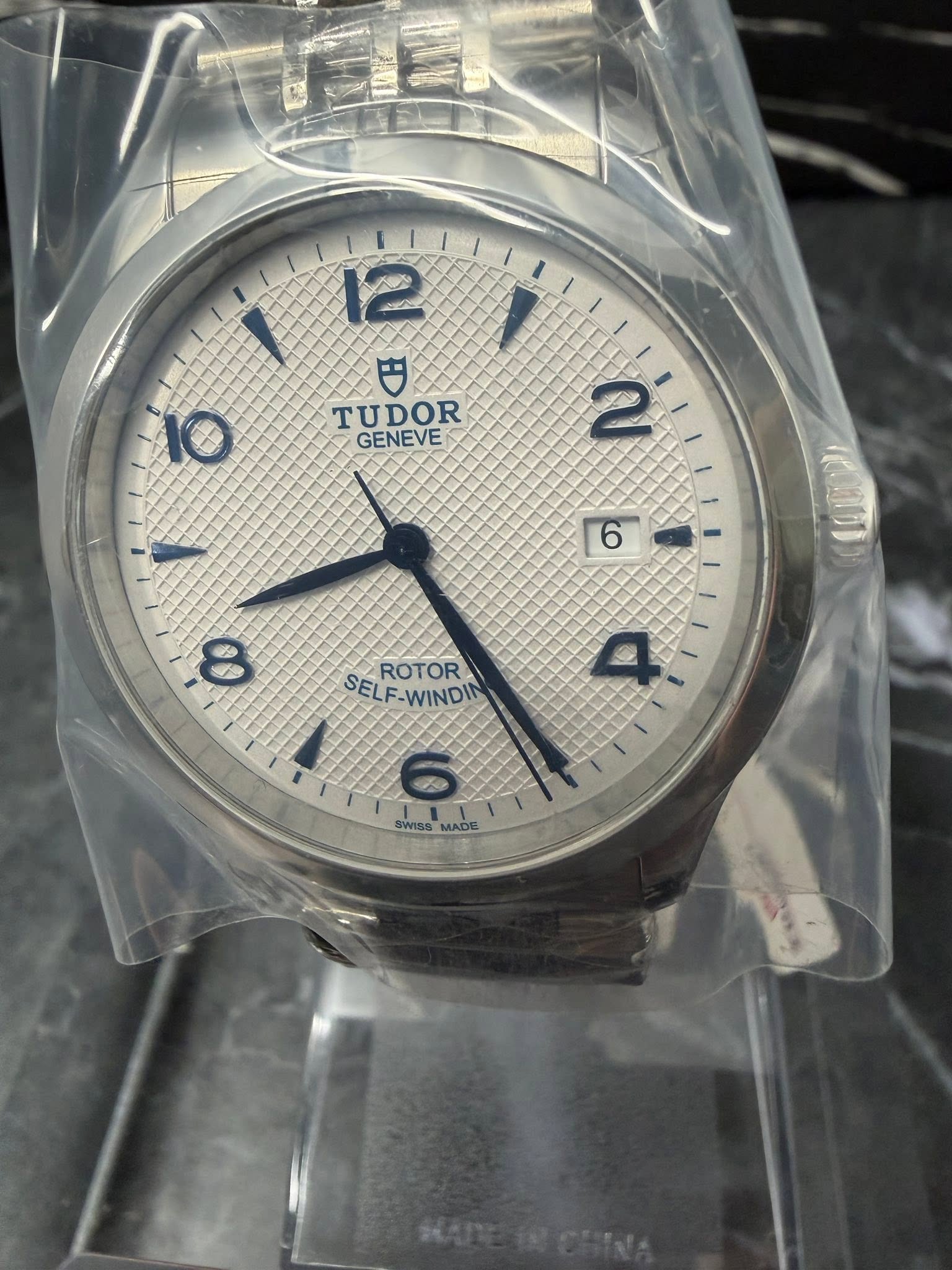 May be an image of wrist watch and text that says '12 TUDOR GENEVE 10 2 6 SEL SELF-WINDI -WINDI ROTOR SWISS AS VADE MADE'