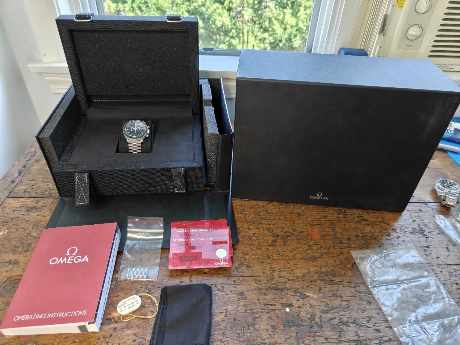 May be an image of leather wallet, wrist watch, saddle-stitched leather, book, suitcase and text that says '------------------ V MASTRE eHKcHcmeTaT മ OMEGA WAR OMEDA…