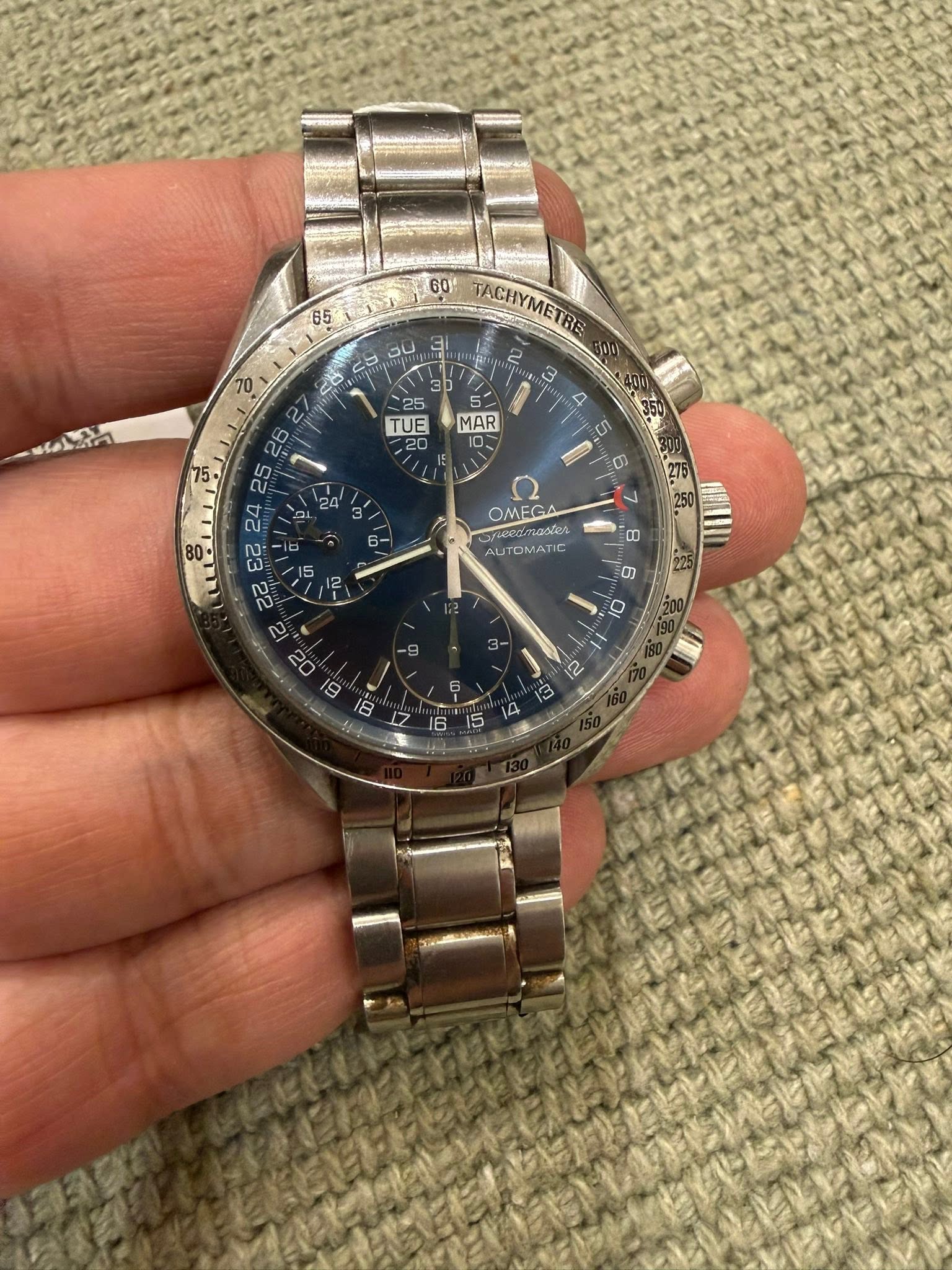 May be an image of wrist watch and text that says '65 DU 60' TACHYMET: BE 00 20 کا 25 TUE MAR દਟ् 22 80 ۲ OMEGA Fieedmastes sadtes AUTOMATIC ወ '