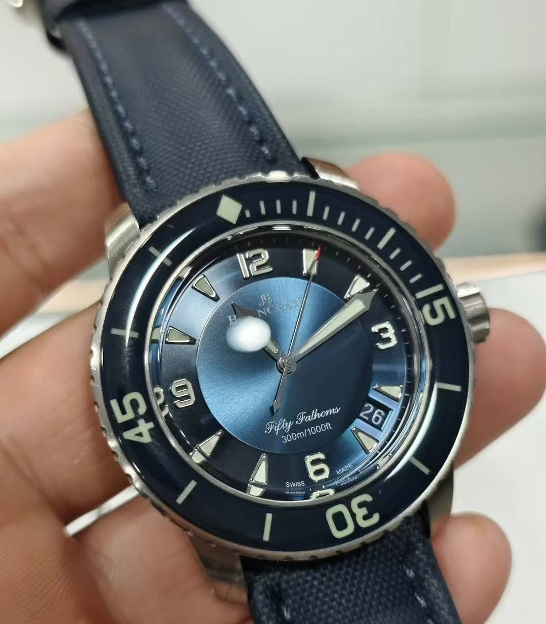 May be an image of wrist watch and text that says '0 B V 15 m 45 D ۱۱ Filly FilyFathoms A Fathoms 26 6 300ml 1000ft SWISS 6 MADE นบอย గ'