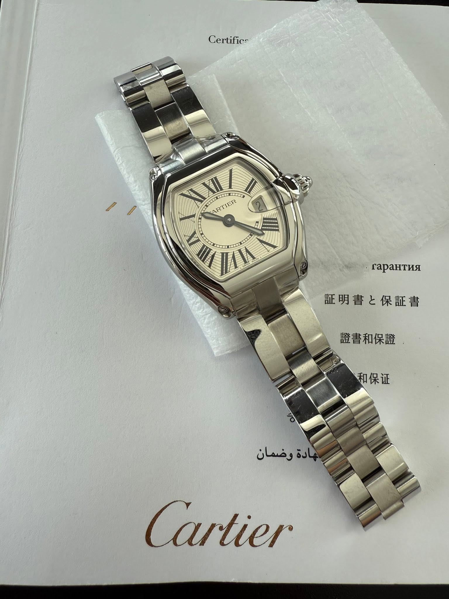 May be an image of wrist watch and text that says 'Cer Certifier XII XII ス ARTIER LX VIILA EI MI rapaHTиR 証明書と保証書 証明 と保証書 證書和保證 和保证 وضمان هادة Cartier'