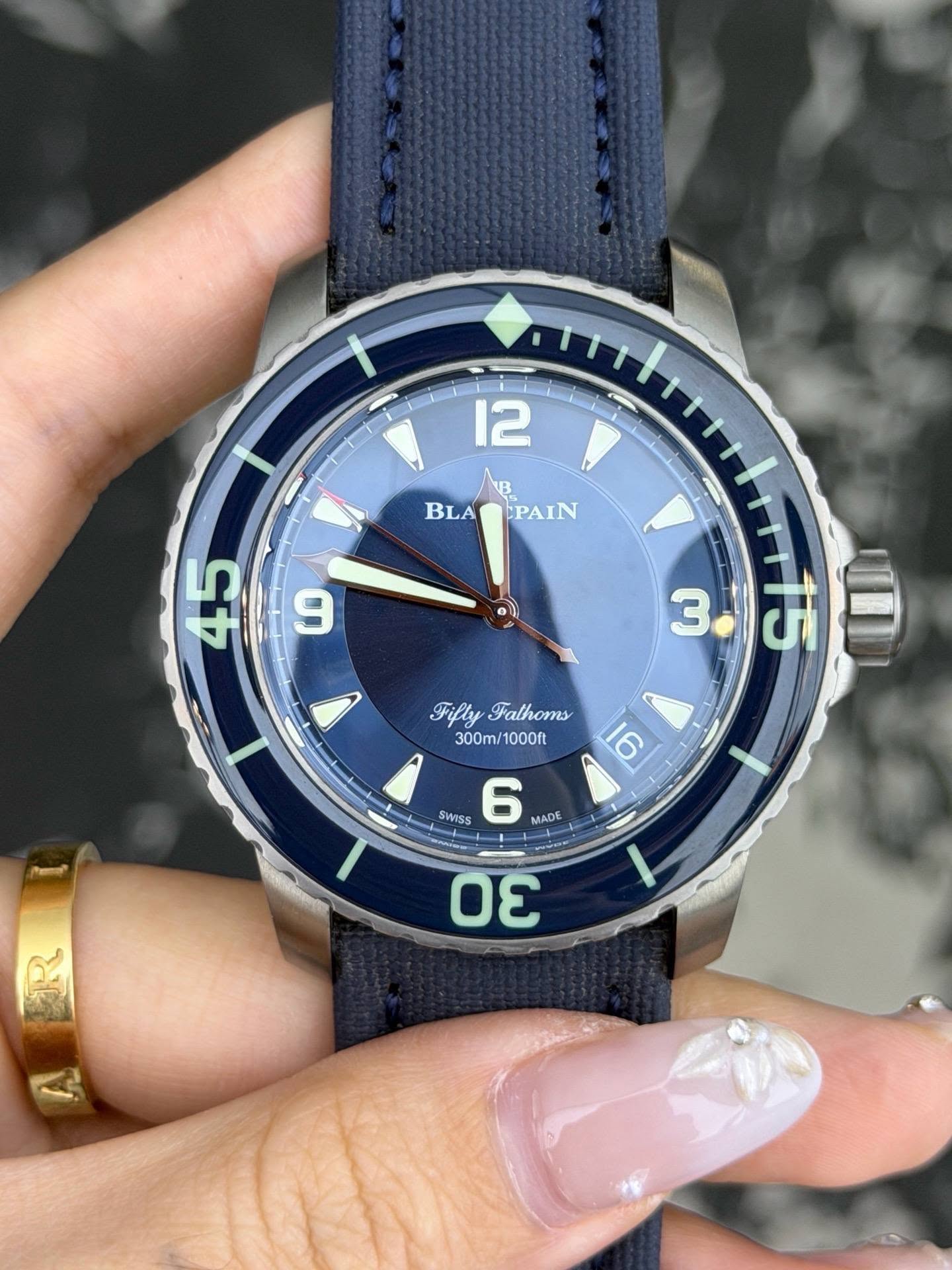 May be an image of wrist watch and text that says '12 B BLADEPAIN BLA CPAIN 49 9 45 " 3.ज 15 3 ١ Fifly FiflyFathoms Fathoms 300m/1000ft 300m/ 1000ft 6 SWISS 6 MADE 30'