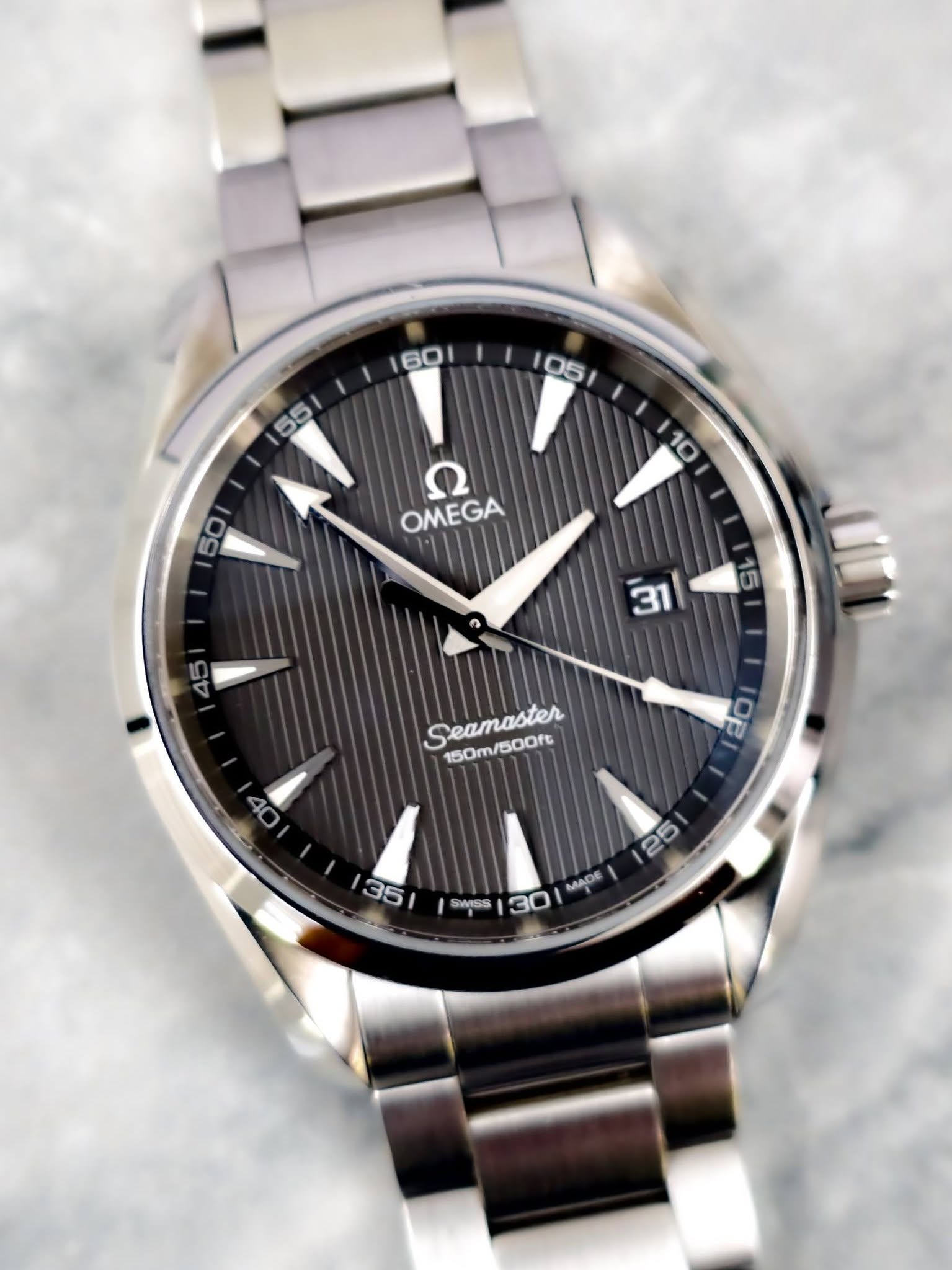 May be an image of wrist watch and text that says 'I 60 05 D5 55 10 50 Ω OMEGA 45 15 31 Seamaster 150m/500ft 40 OE 35 25 SWISS MADE 30'