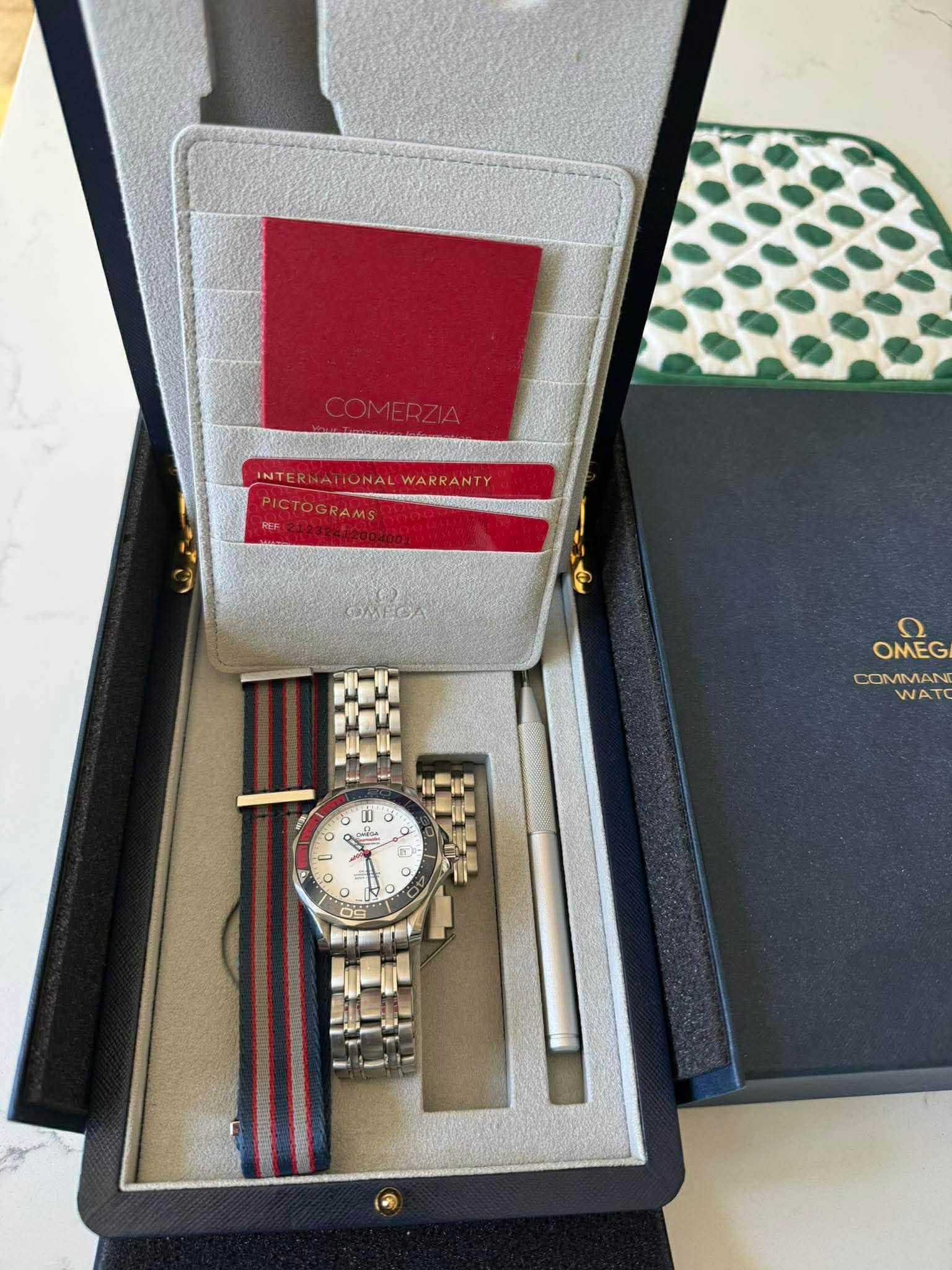 May be an image of wrist watch and text that says 'COMERZIA INTERNAT INTERNATIONALWARRANTY ONAL WARRANTY PICTOGRAMS OMECA OMEG ח OMEG COMMAN WATO - စး O - . c -'
