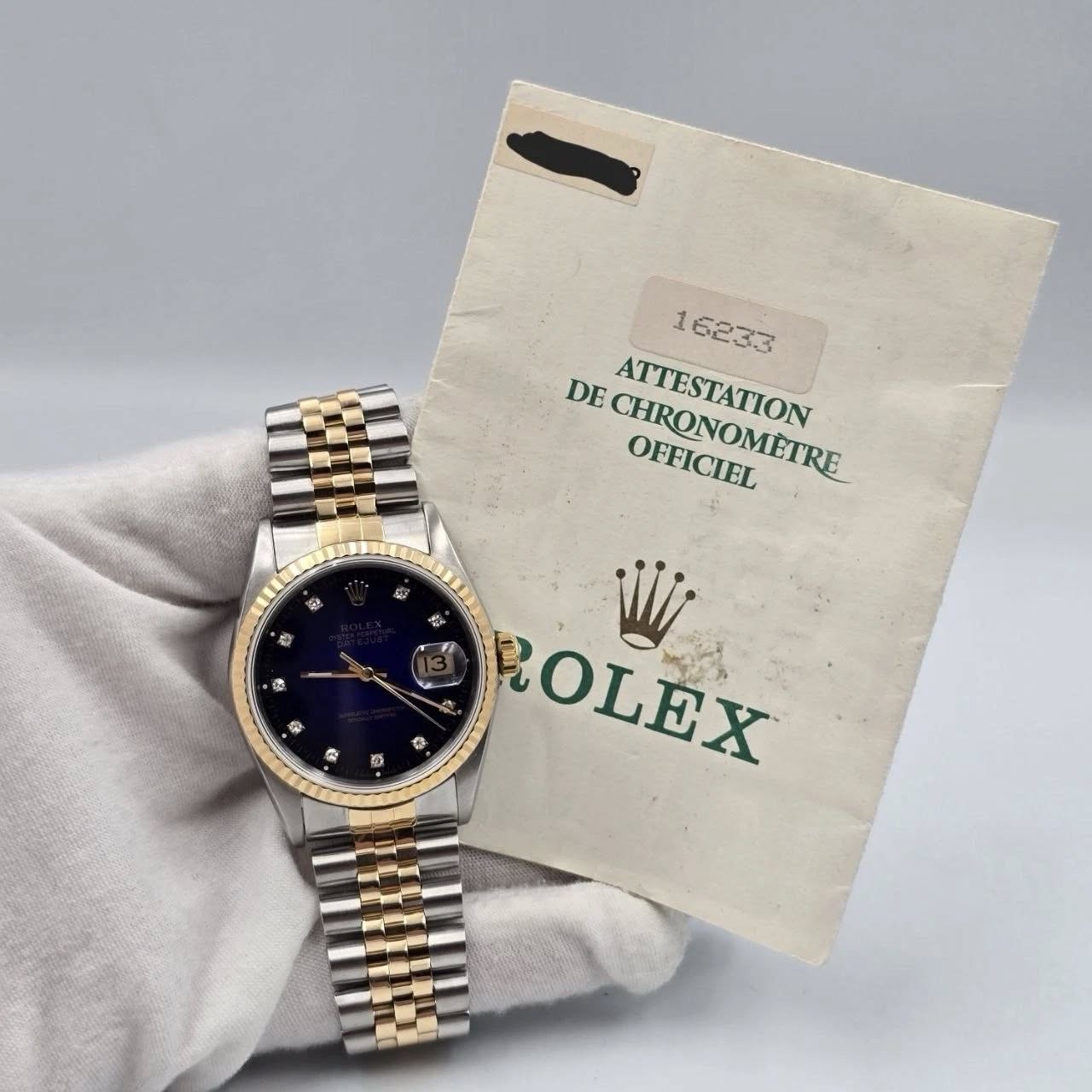 May be an image of wrist watch and text that says 'ل 1 16233 DE CHNONONETRE CHRONOMETRE OFFICOMETRE OFFICIEL ATTESTATION 記 ROLEX Wli @ 4 2 寺 و سن سور ® 表 C 極'