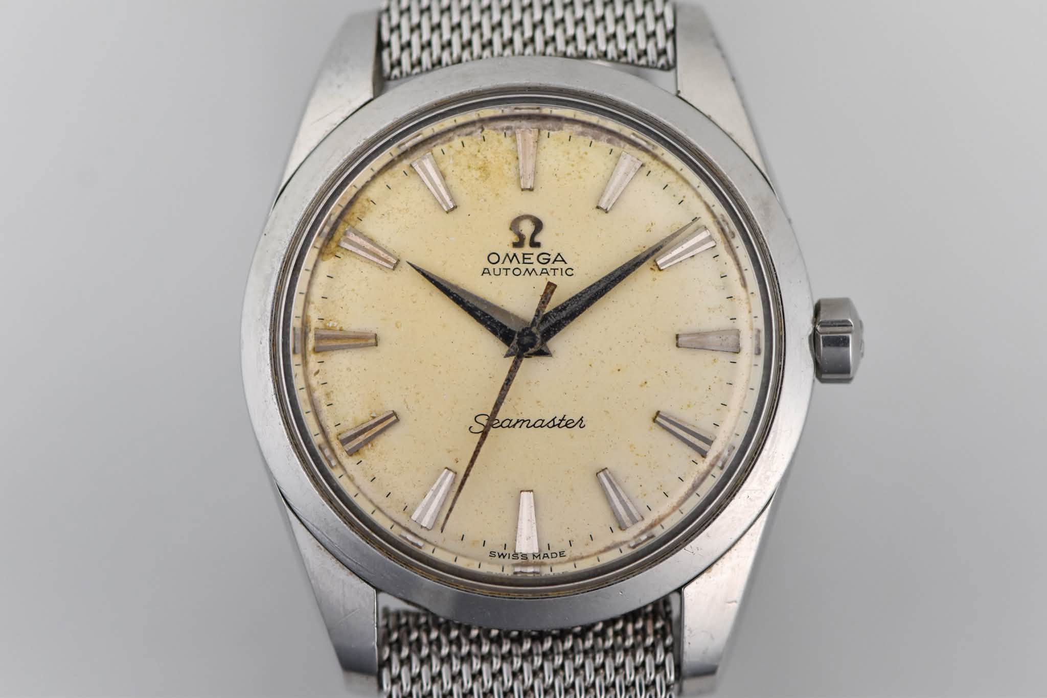 May be an image of wrist watch and text that says '9 OMEGA OME GA AUTOMATIC I SWIS'S WISSMAD MADE'
