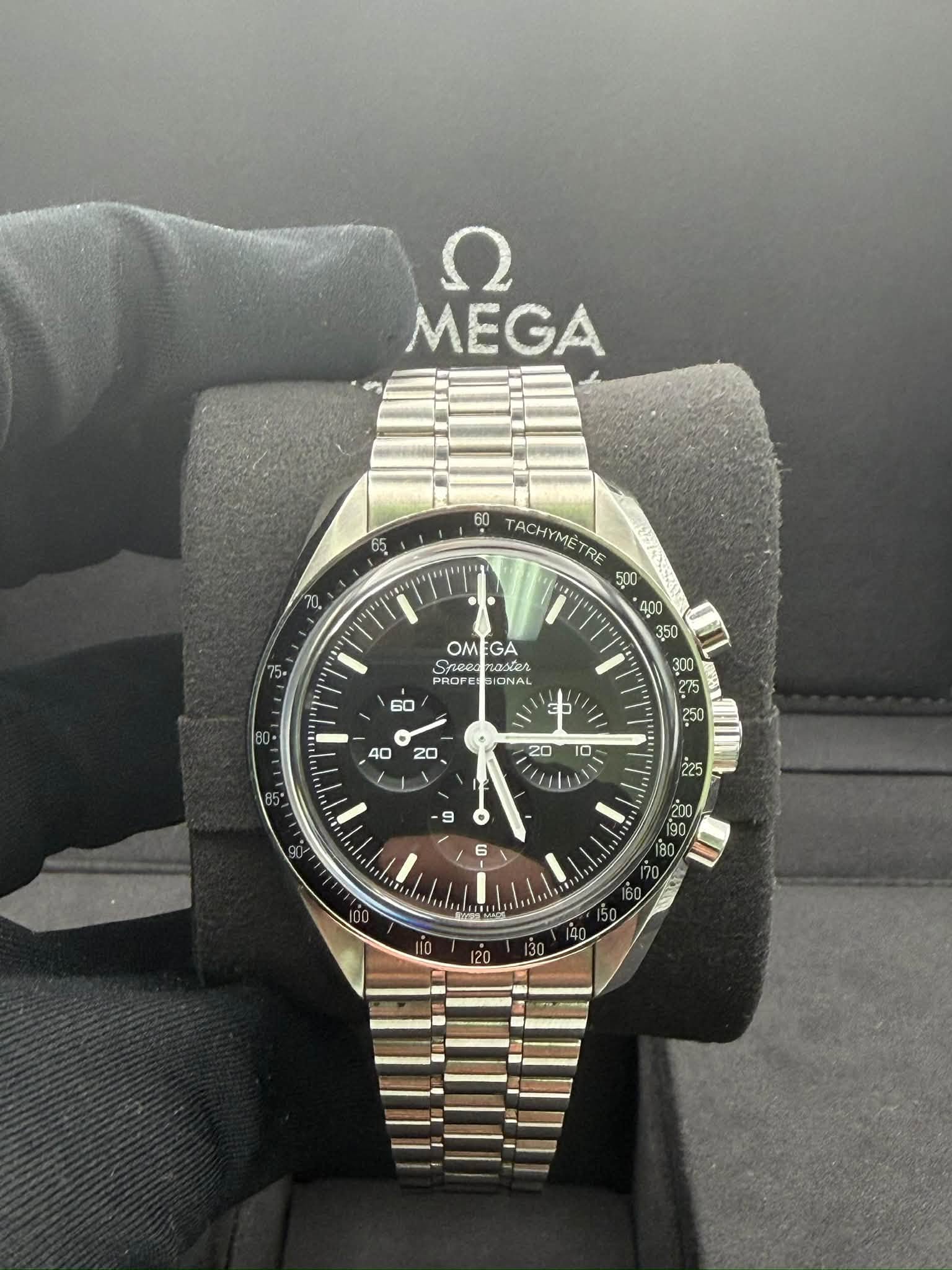 May be an image of wrist watch and text that says 'Ω MEGA 65 10 60 ACHYMETRE TACHYMETRE TRE ش 300 250 OMEGA OM GA ටෝබට Snee жeл PROFE PROFE SIONAL • 6 C2 2 0 E0 200 80 0E S'