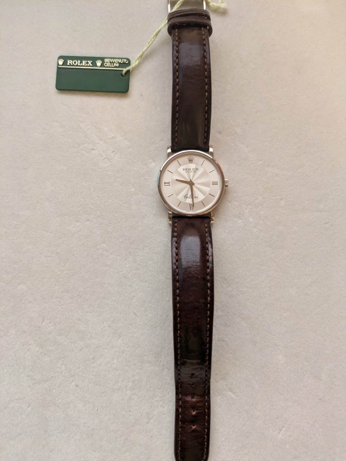 May be an image of wrist watch, leather and text