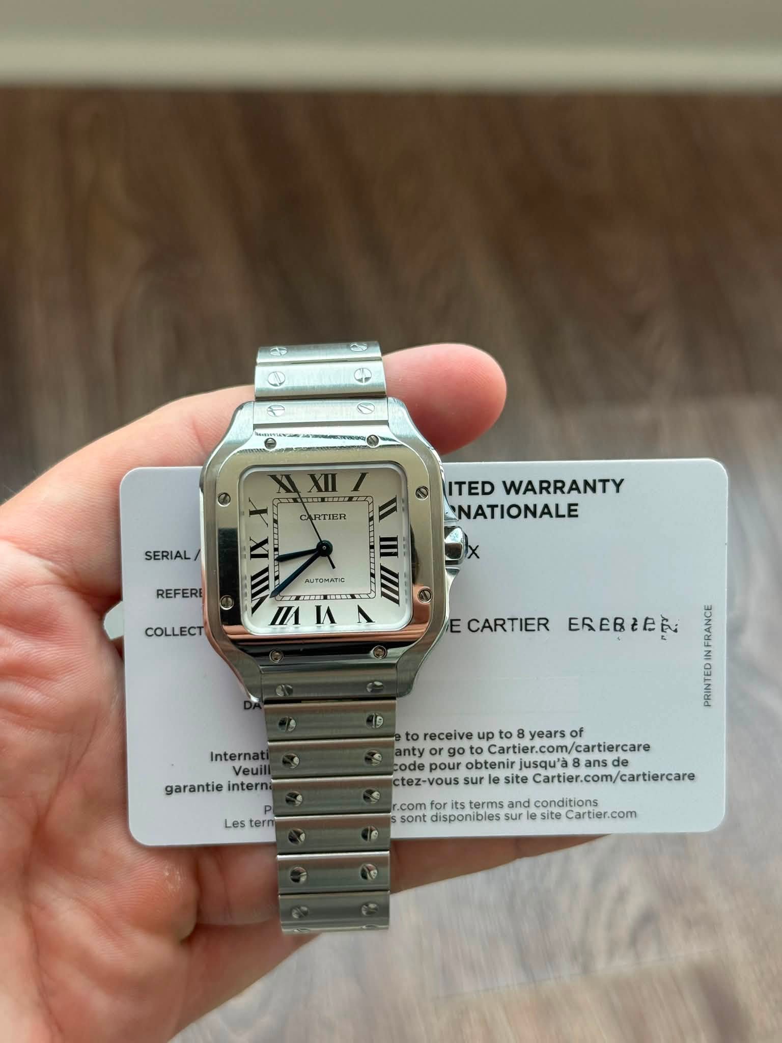 May be an image of wrist watch and text that says 'RTIER SERIAL/ ITED WARRANTY NATIONALE REFERI AUTOMATIC COLLECT MIA I/1 IA E CARTIER EREBIEN Internat Veuill garantie interni Les…