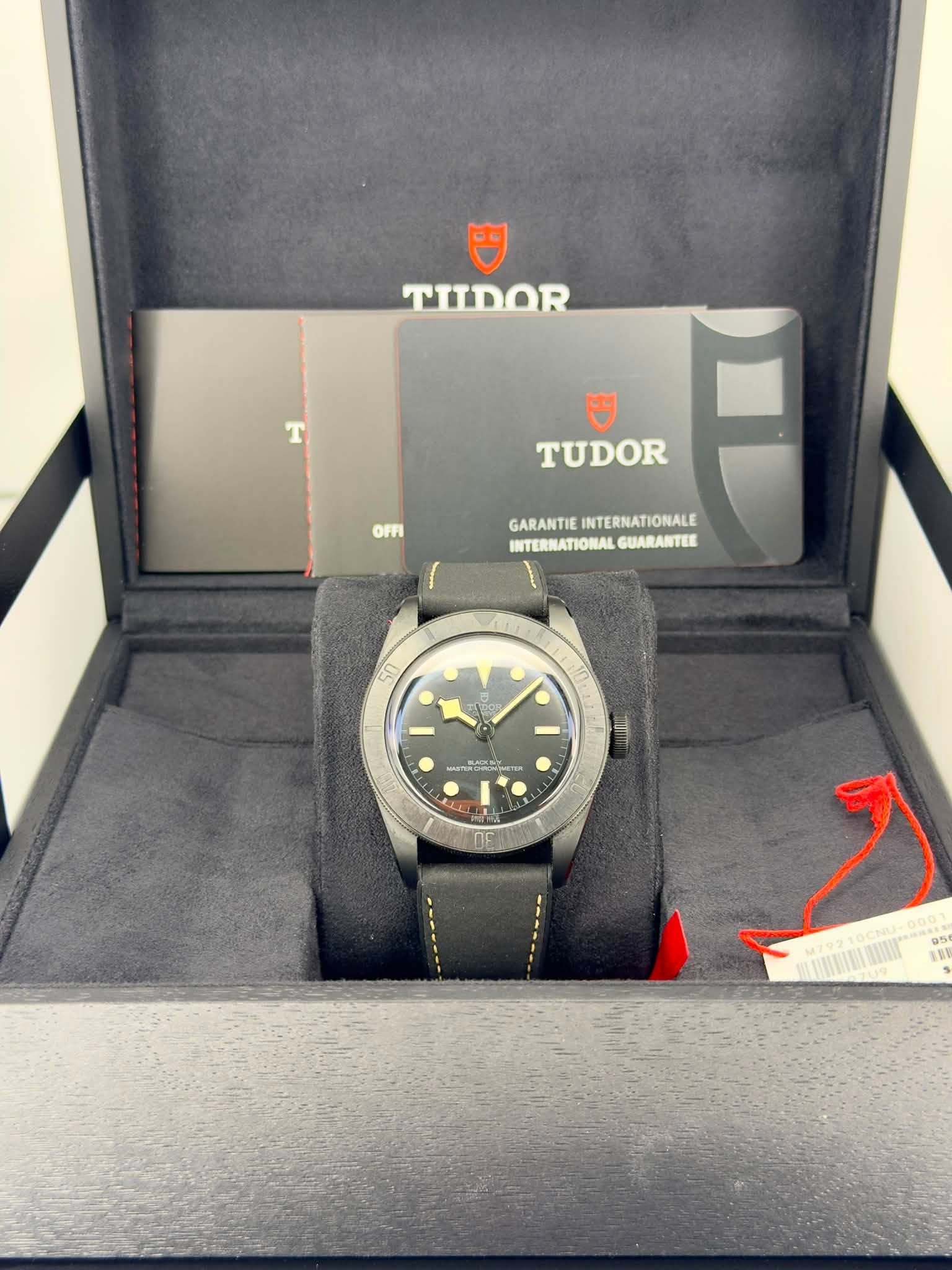 May be an image of wrist watch and text that says 'TIIDOR TUDOR OFFI GARANTIE GARANTIEINTERNATIONALE INTERNATIONALE INTERNATIONAL GUARANTEE O CUIIIA LLDN LY ا 05 MU92A 无就電'