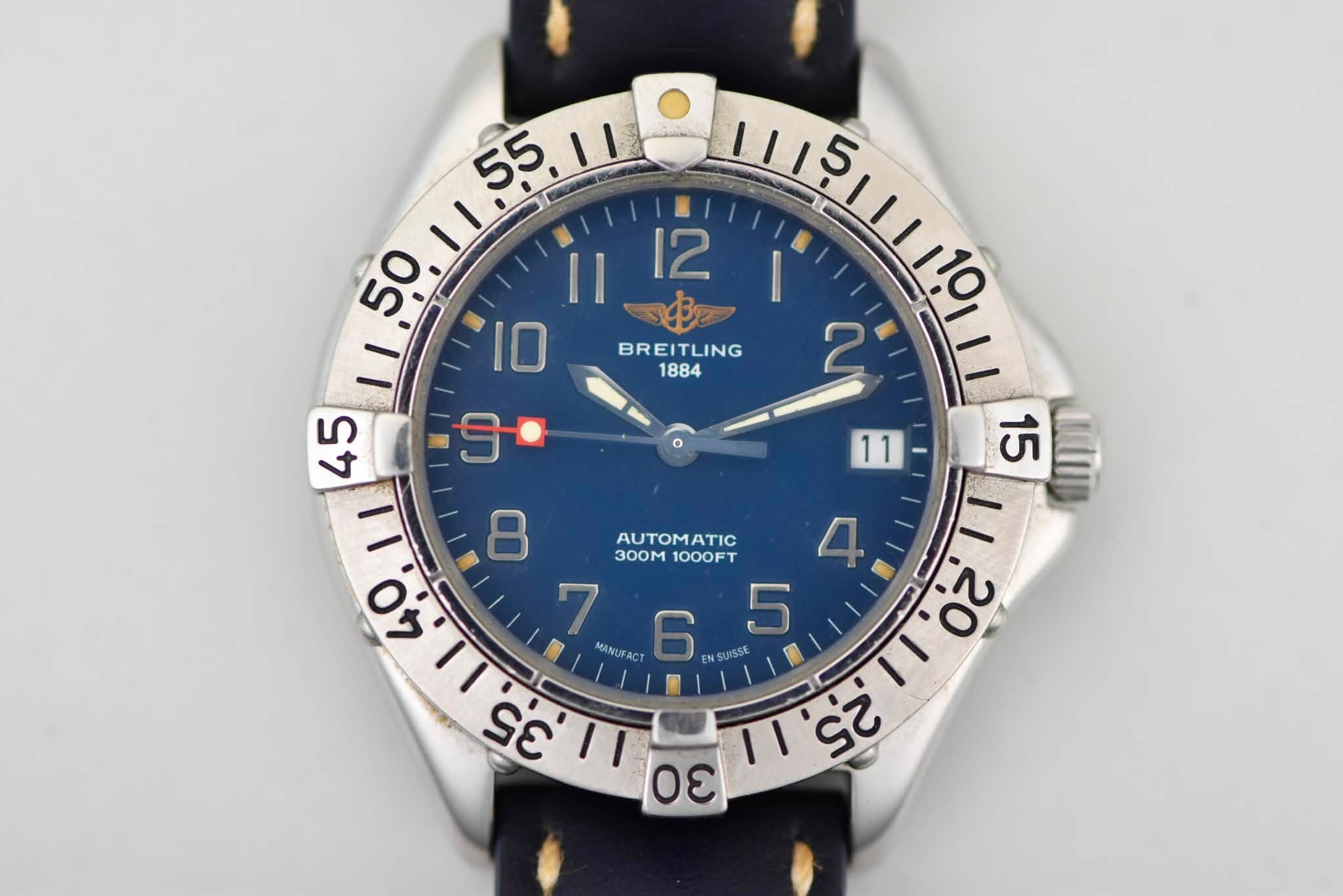 May be an image of wrist watch and text that says '55.11 55 1I 50 Il 12 TLING 111틴!111일 ١١١1 10 BREITLING BREI 1884 45 ل AUTOMATIC 3OOm 1000FT 4 7 765 ENS SUISSE 5 11,20 N-RE 1I…