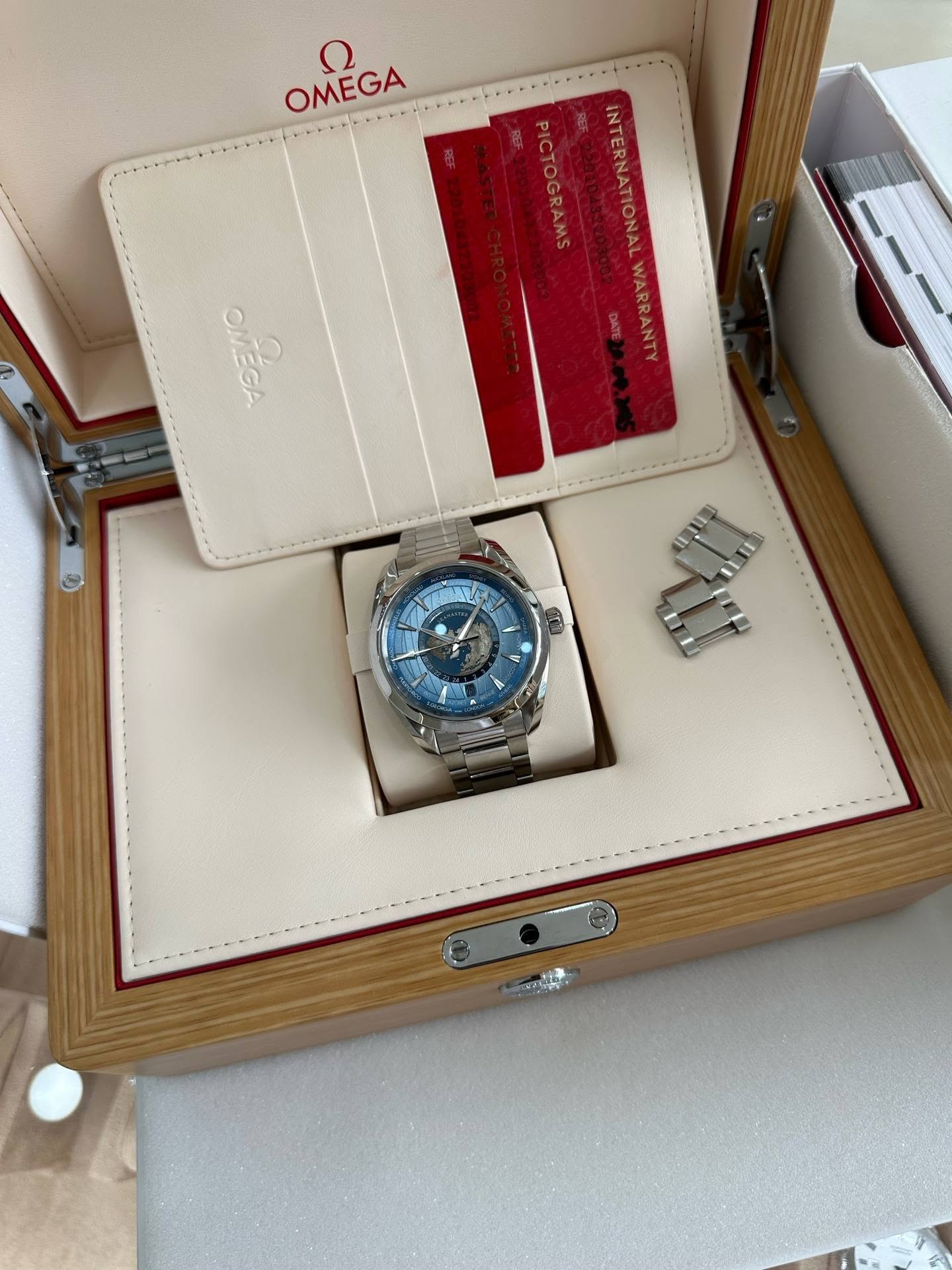 May be an image of wrist watch and text that says 'ח OMEGA PICTOGRAMS INTERNATIONALWARRANN REE INTERNATIONALWARRANT WARRANTY OGRAMS OMÉGA'