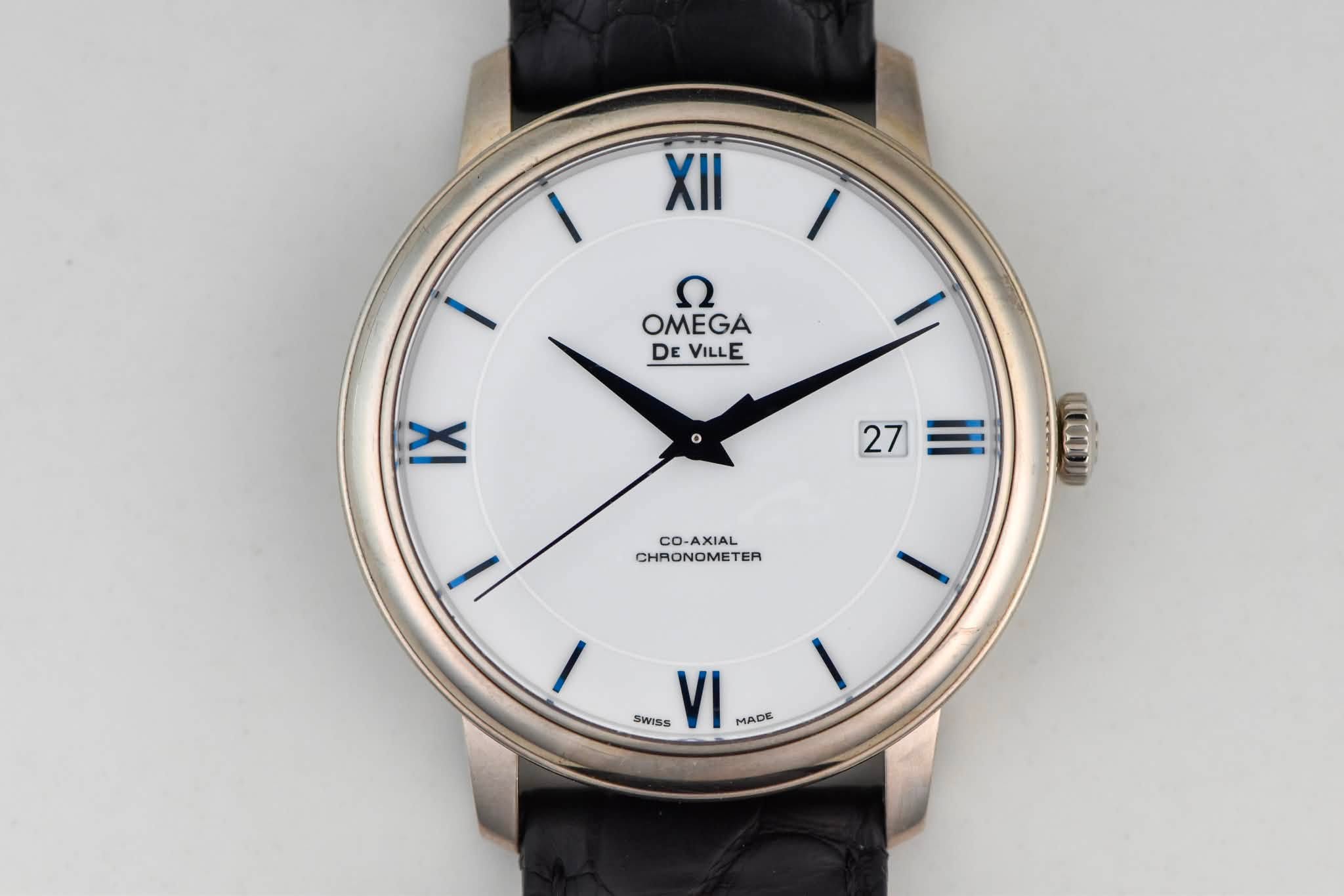 May be an image of wrist watch and text that says 'XII OMEGA DE VILLE E IX 27 (1004) CO-AXIAL CHRONOMETER TER SWISS VI MADE'